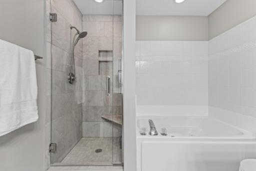 Enjoy the spa like feel with the custom tiled shower, glass door and ceramic tile surround on the bath.