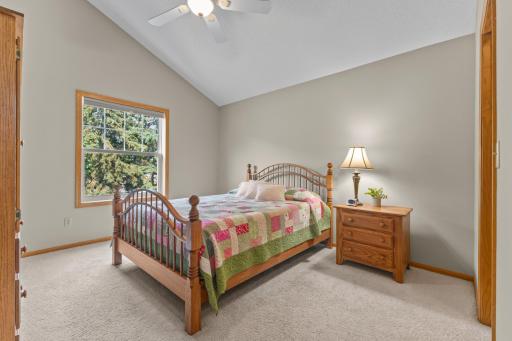 The primary bedroom continues the spacious feel with the vaulted ceiling, neutral carpet, walls & ceiling fan for all year comfort.