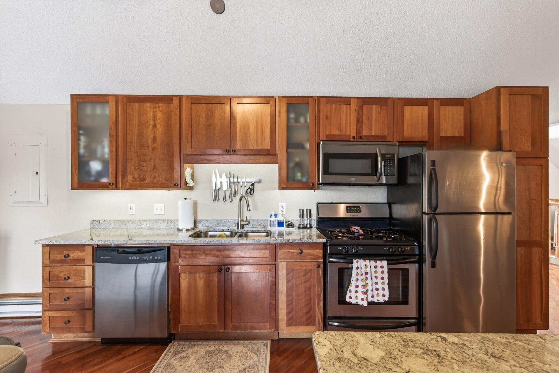 The modern kitchen features granite countertops, stainless steel appliances, and a center island.