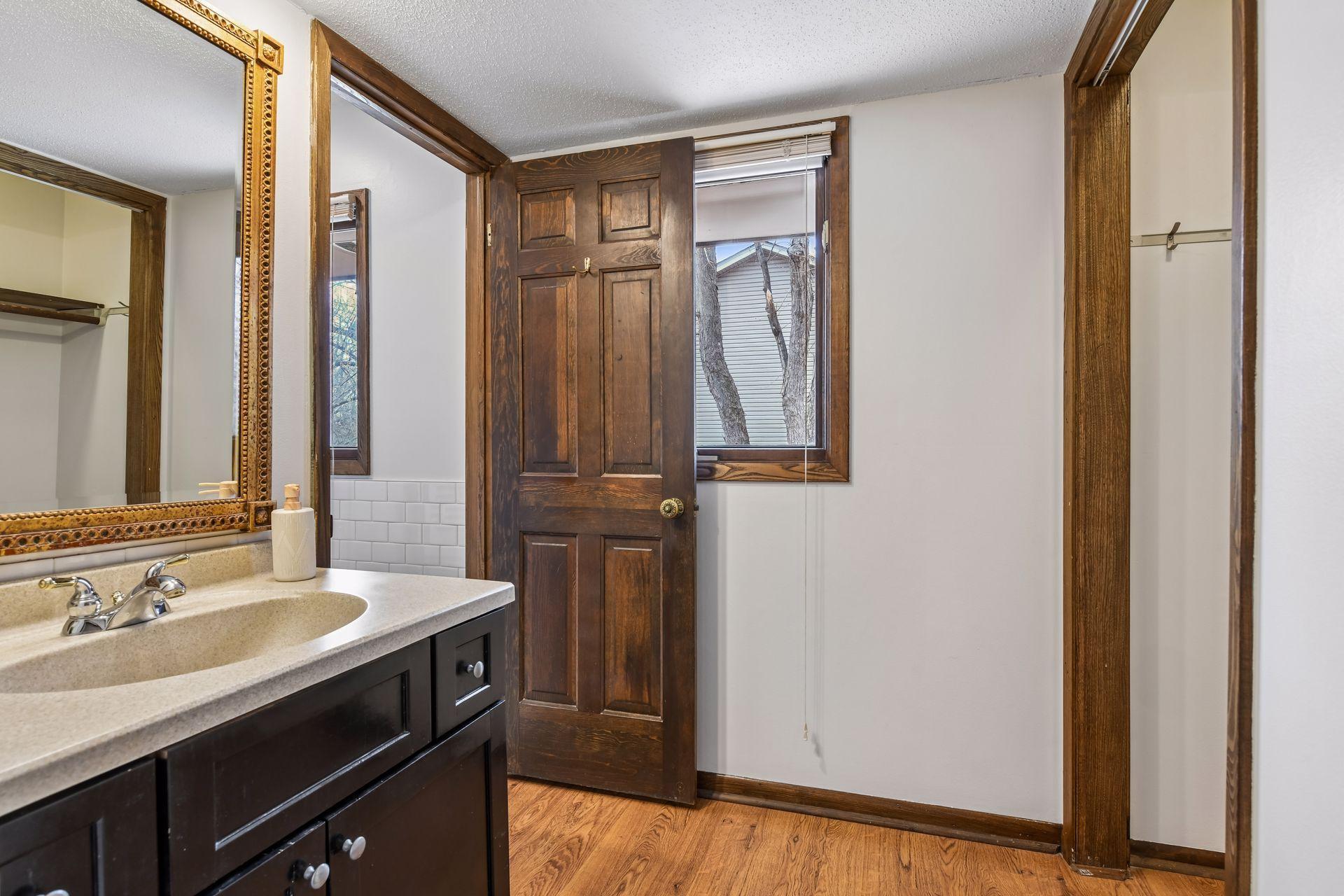 14x13 Upper Level Primary Bedroom with an en-suite 3/4 bathroom. Newly refinished oak hardwood floors and fresh paint. West-facing sliding glass windows open to a private west-facing deck.