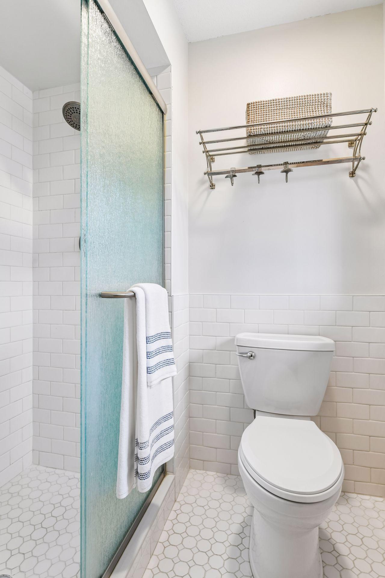 14x13 Upper Level Primary Bedroom with an en-suite 3/4 bathroom. Newly refinished oak hardwood floors and fresh paint. West-facing sliding glass windows open to a private west-facing deck.