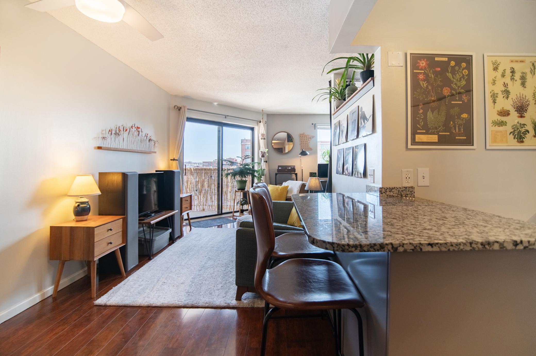 Granite countertops, wood floors and tasteful design elements create a warm and inviting space in this studio condo.