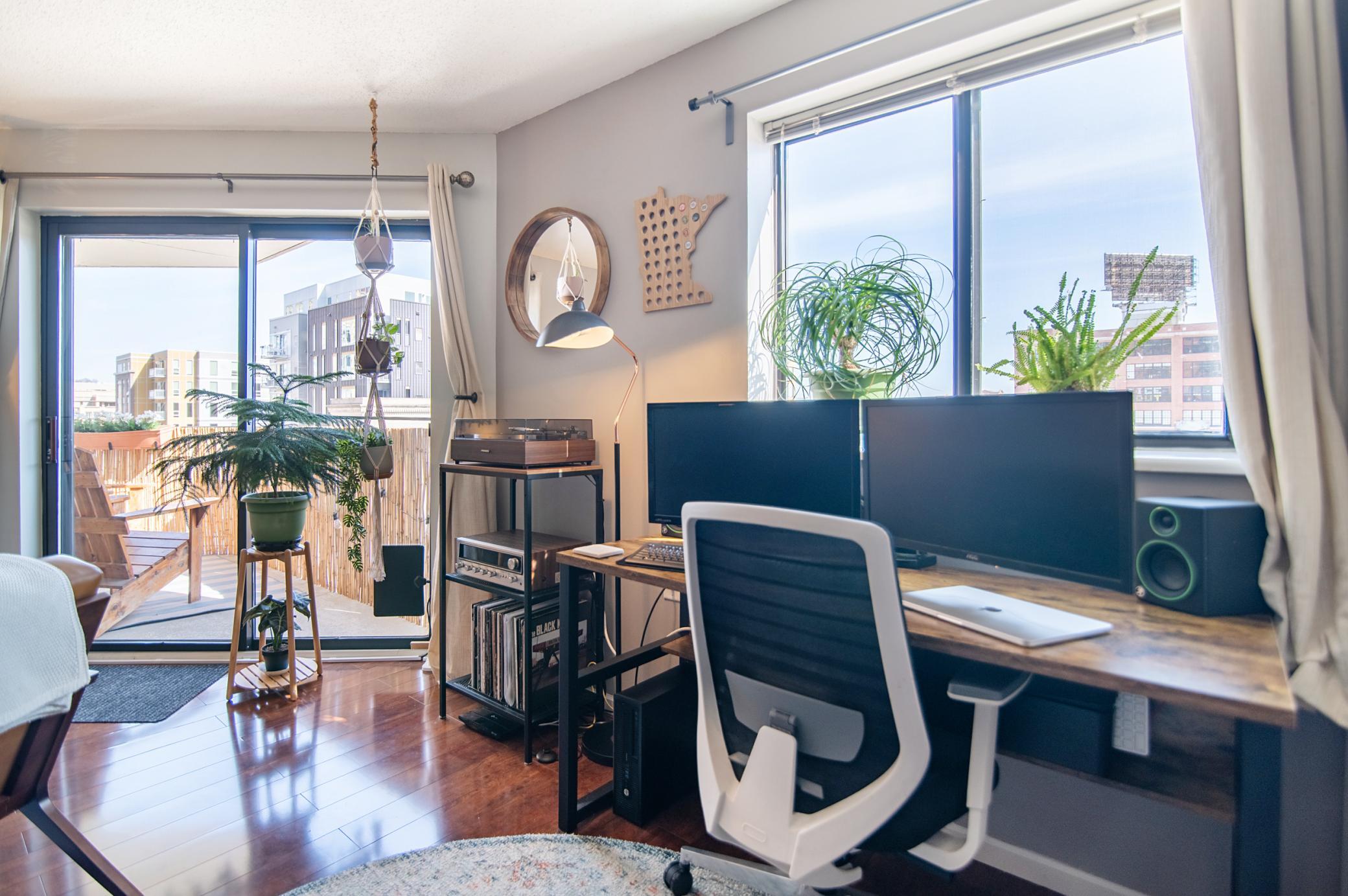 The window and balcony feature panoramic views of Downtown Saint Paul and overlook Pedro Park.