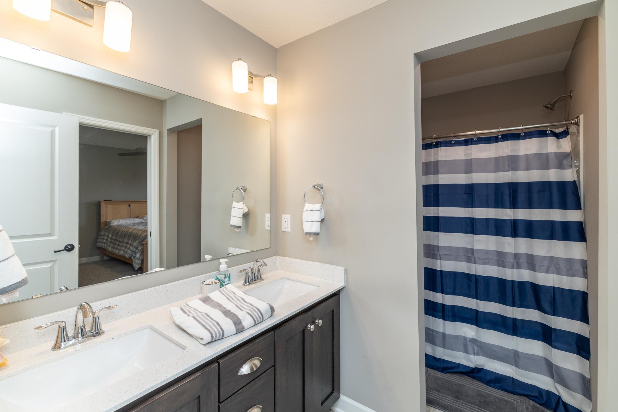Full Jack-and-Jill bathroom with dual vanities, thoughtfully designed with direct access from two bedrooms
