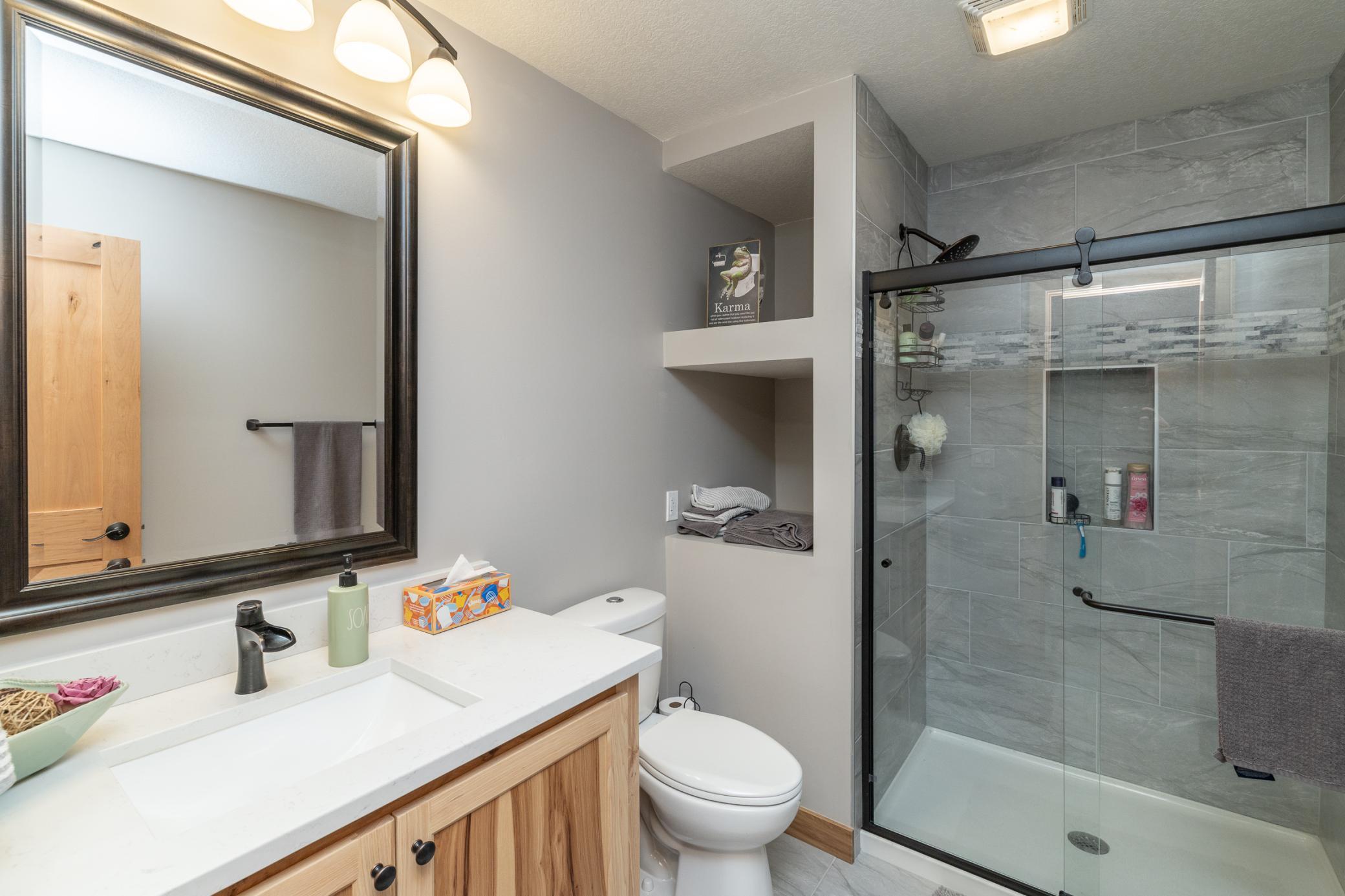 Lower-level bathroom with vanity and glass-enclosed shower
