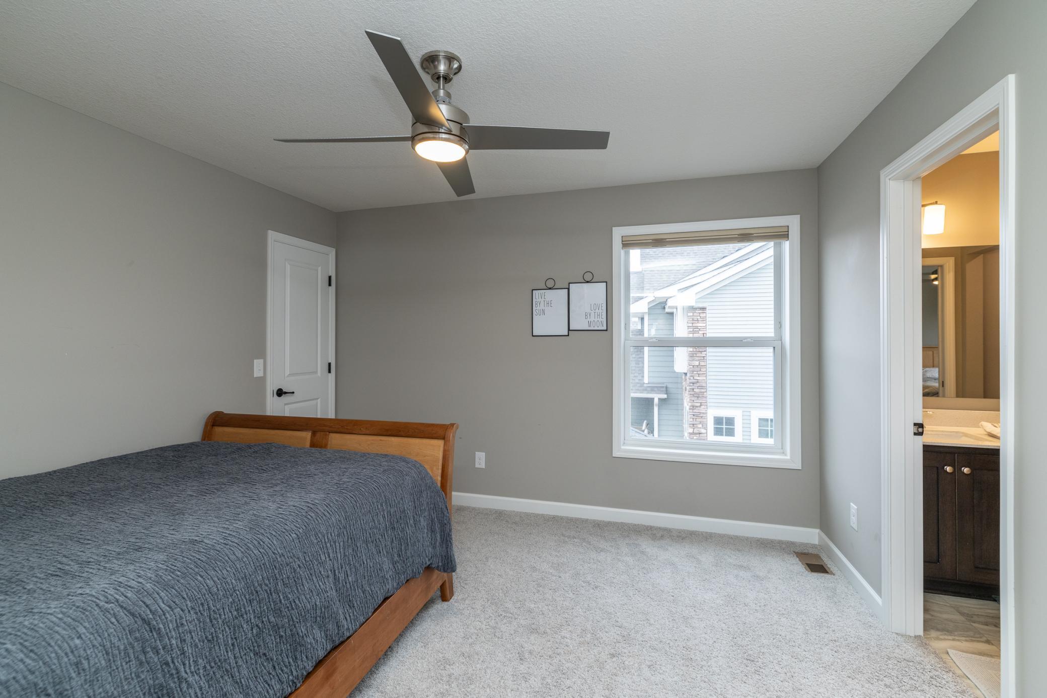 Spacious secondary bedroom with neutral finishes and large window and a connecting jack and jill bathroom