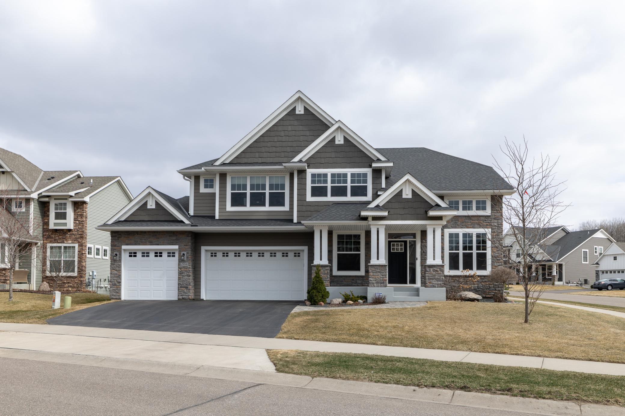 Beautiful curb appeal with welcoming front porch and a heated three-car garage