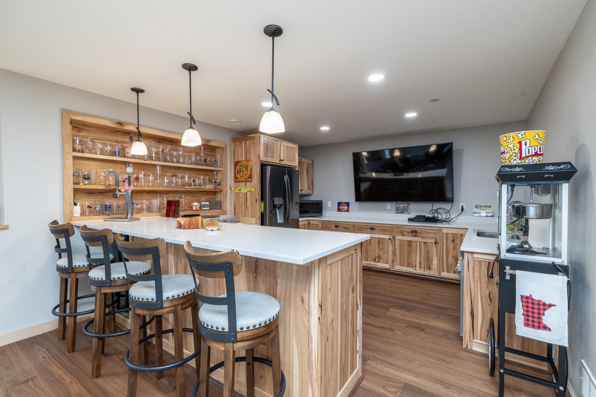 Exceptional lower-level bar area with custom cabinetry and oversized peninsula seating