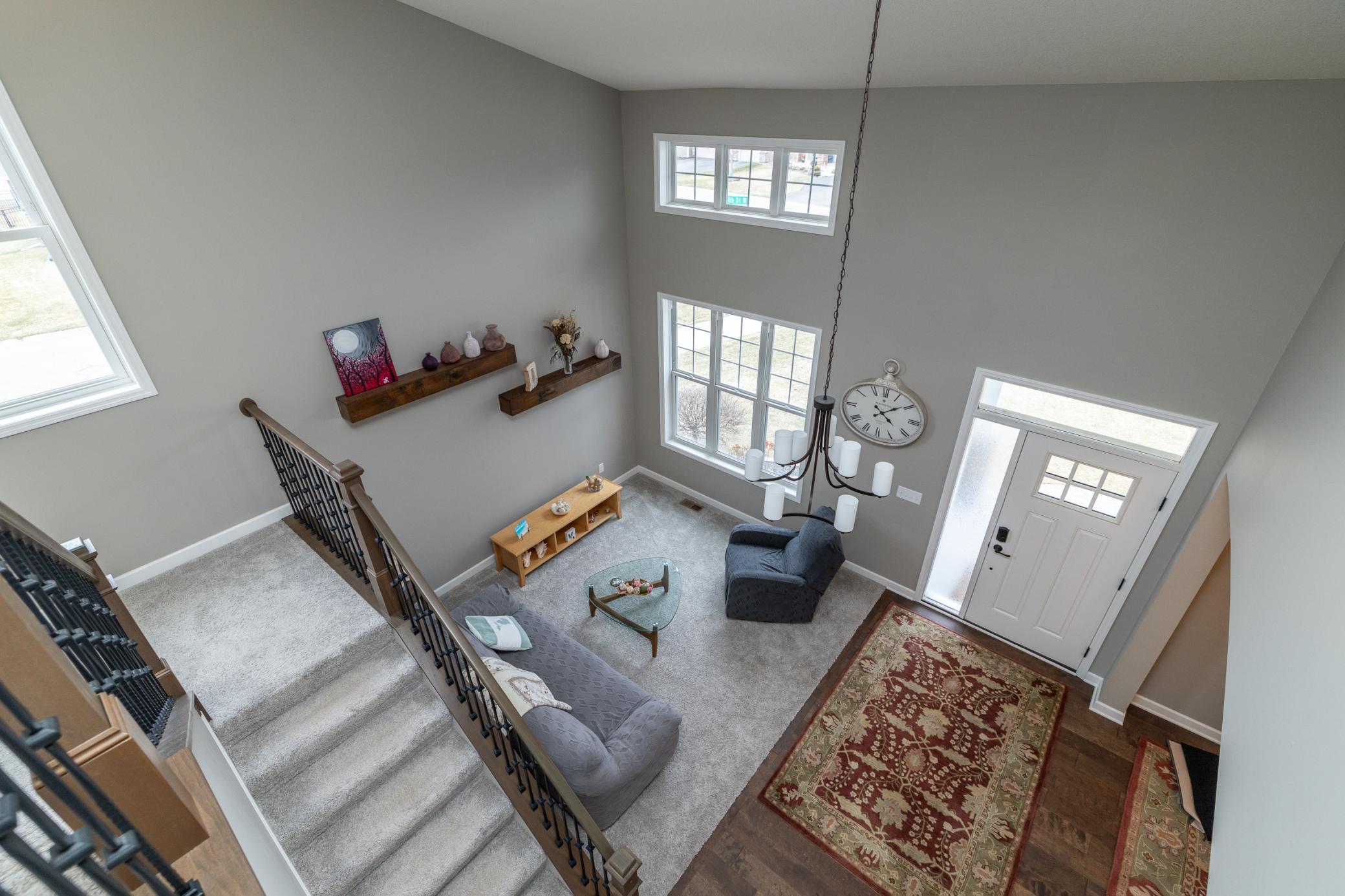 Elegant staircase and welcoming entry with impressive two-story feel