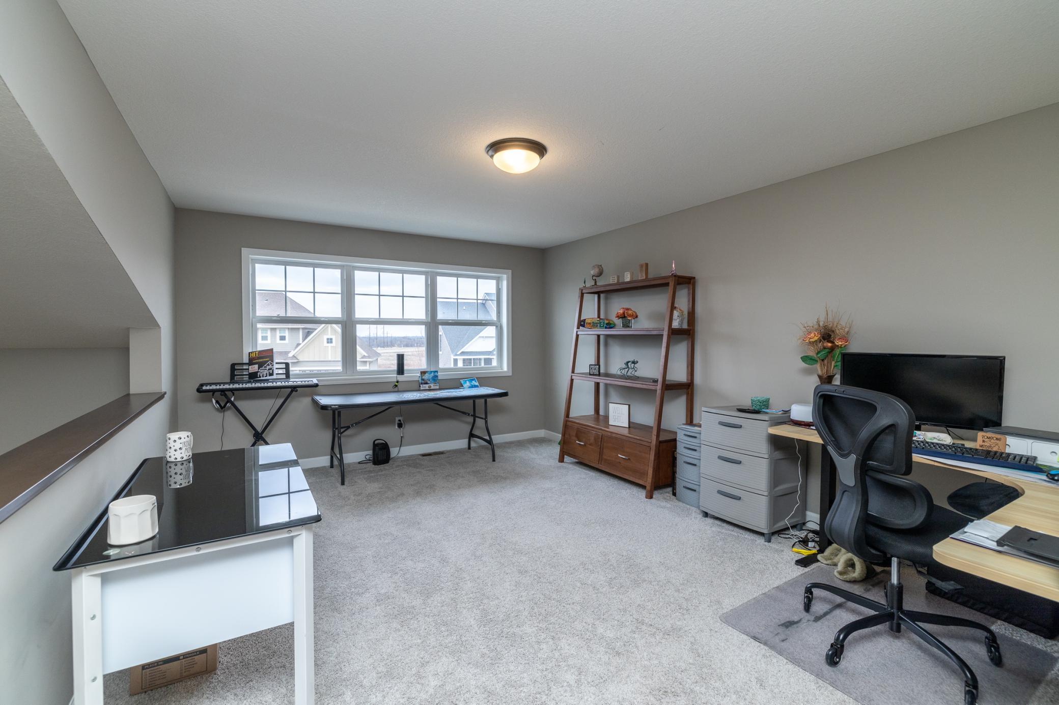 Bright upper-level loft with oversized window, perfect for a home office, playroom, or flex space