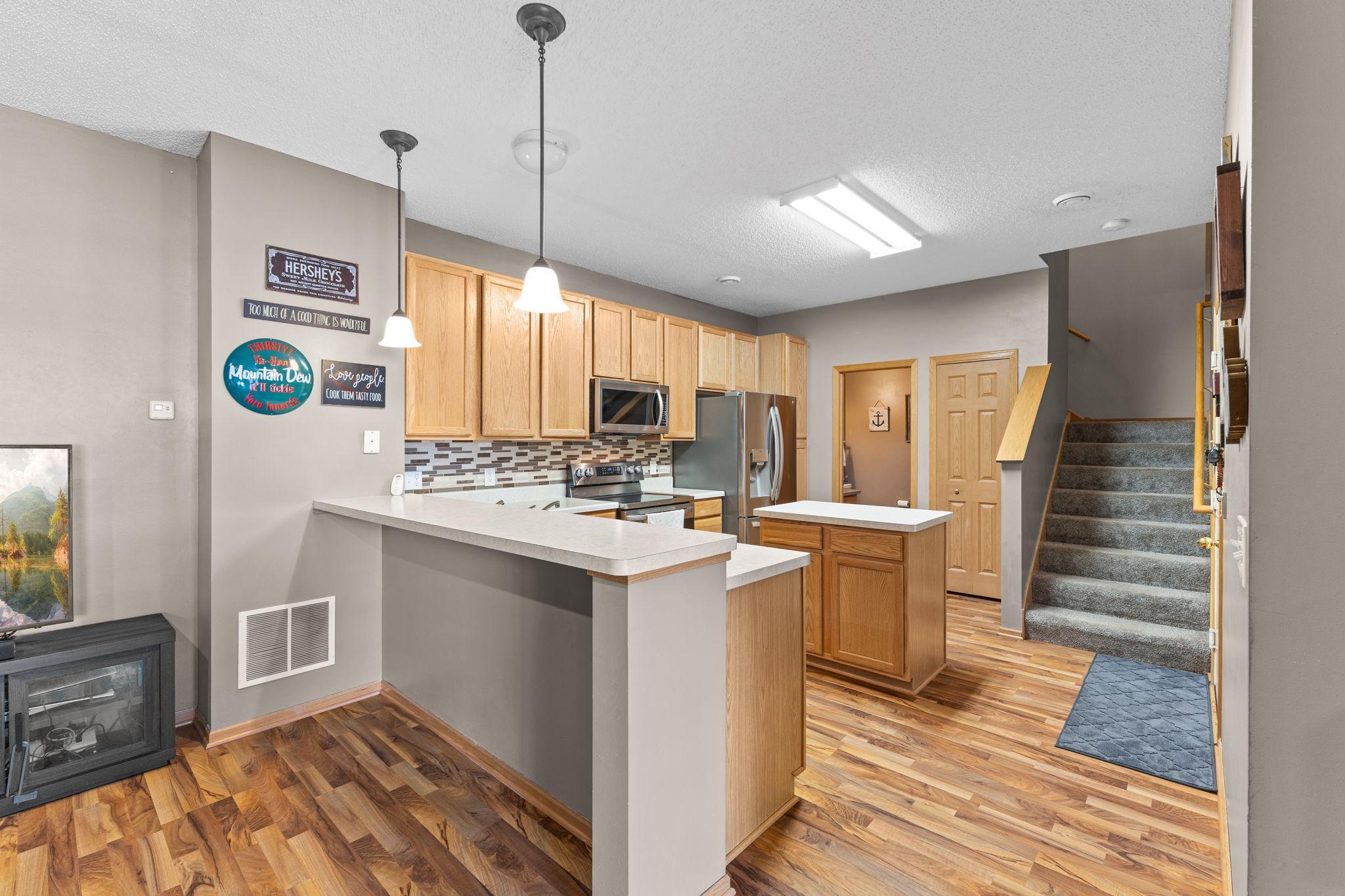 Functional kitchen with ample cabinetry, counter space, and breakfast bar