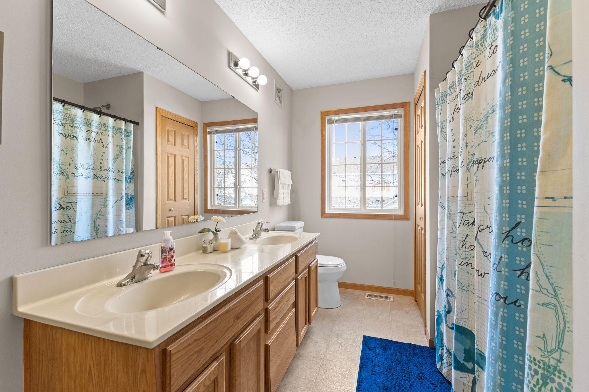 Full bath with dual vanity and great natural light