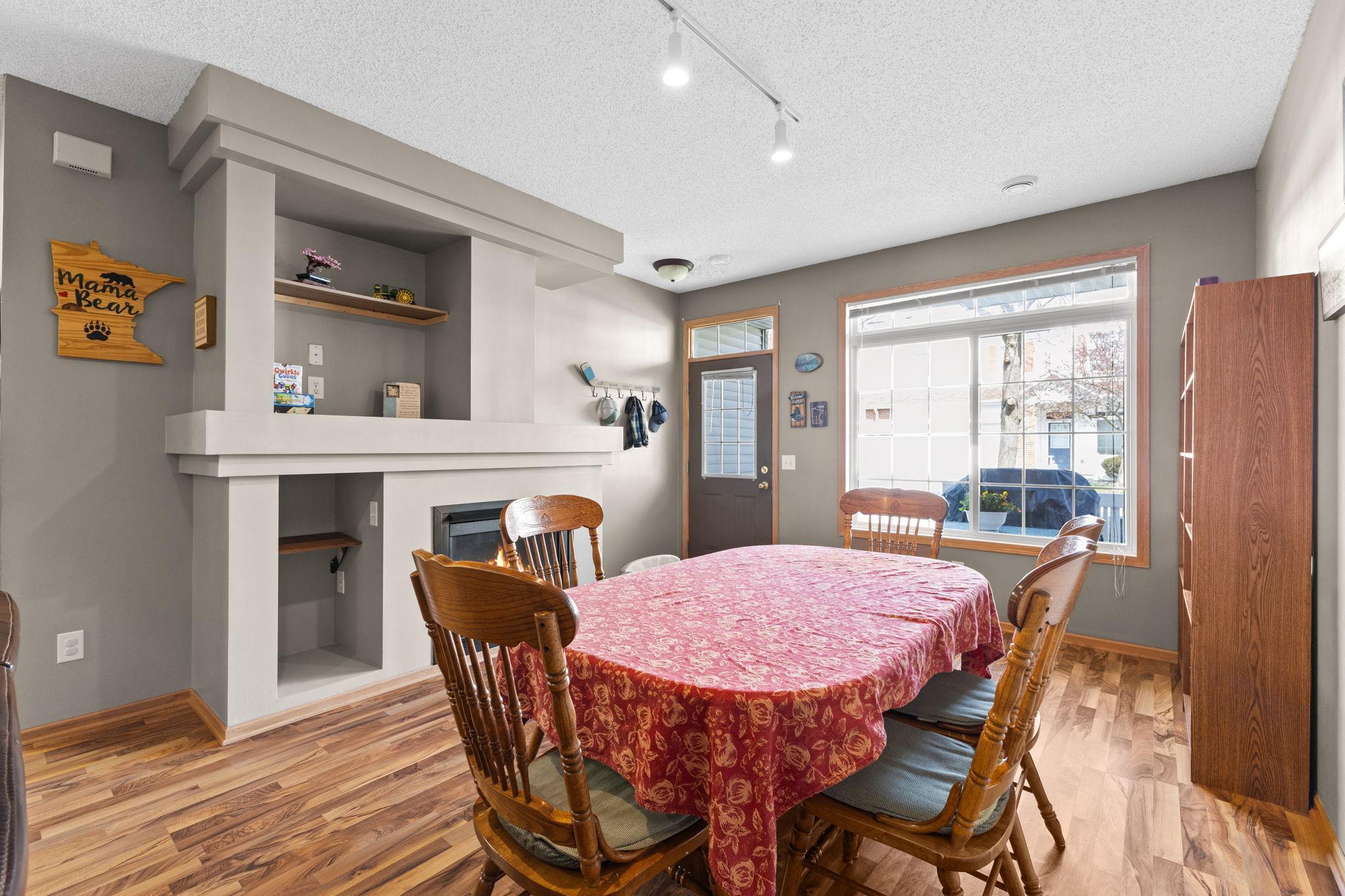 Light-filled front room with fireplace—styled as dining, designed for flexibility.