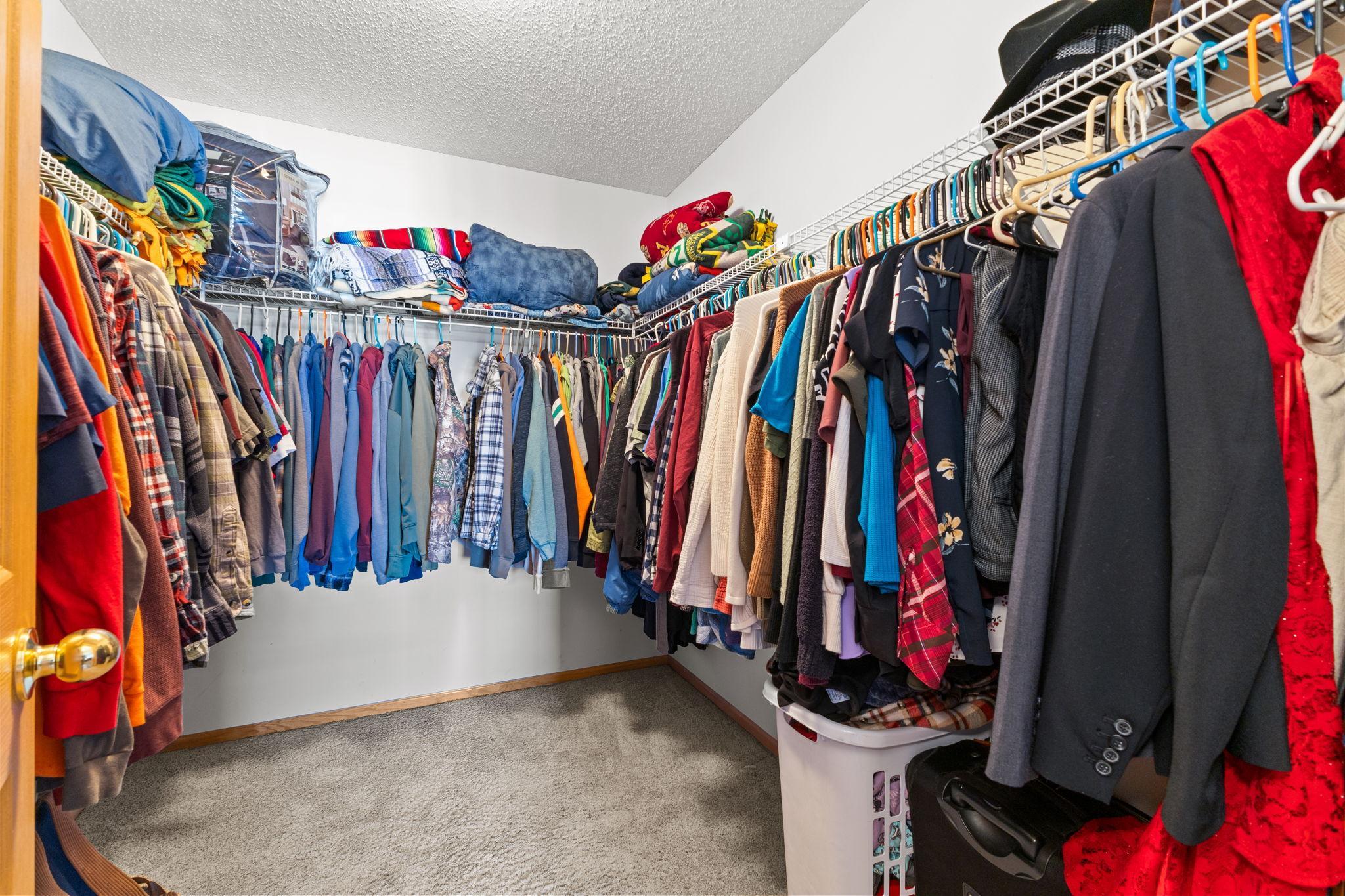 Generous walk-in closet with built-in shelving and hanging space