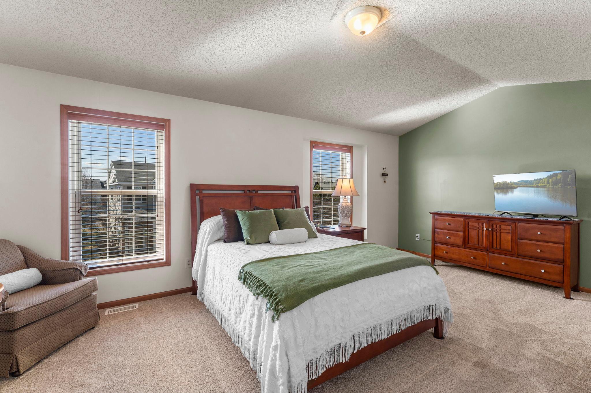 At the far end of the hallway is your primary retreat! This room is so spacious and relaxing - vaulted ceiling and subtle colors, not to mention brand new carpeting.