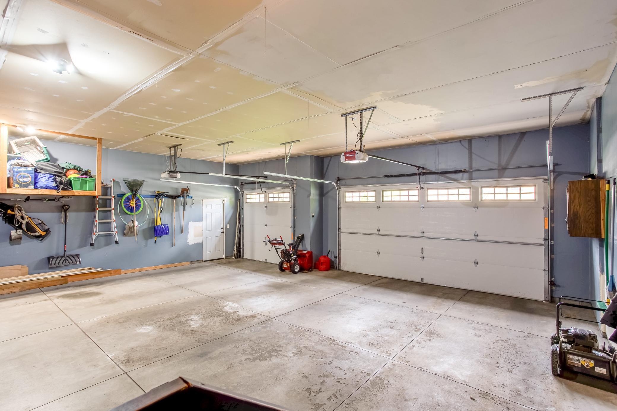 Expansive 3-car garage with oversized doors, abundant storage, and plenty of room for vehicles, tools, and recreational equipment.