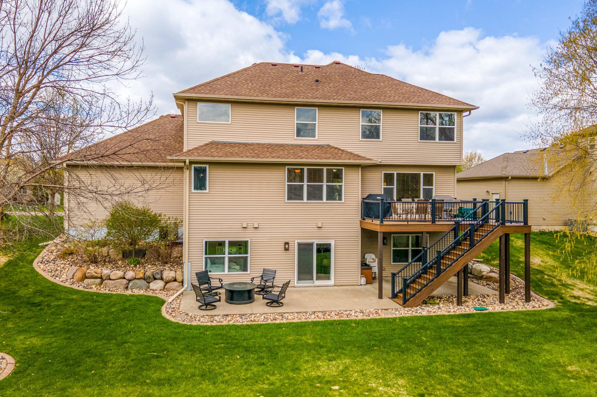Expansive backyard retreat featuring a large maintenance-free deck, walkout lower level, and beautifully landscaped yard space.