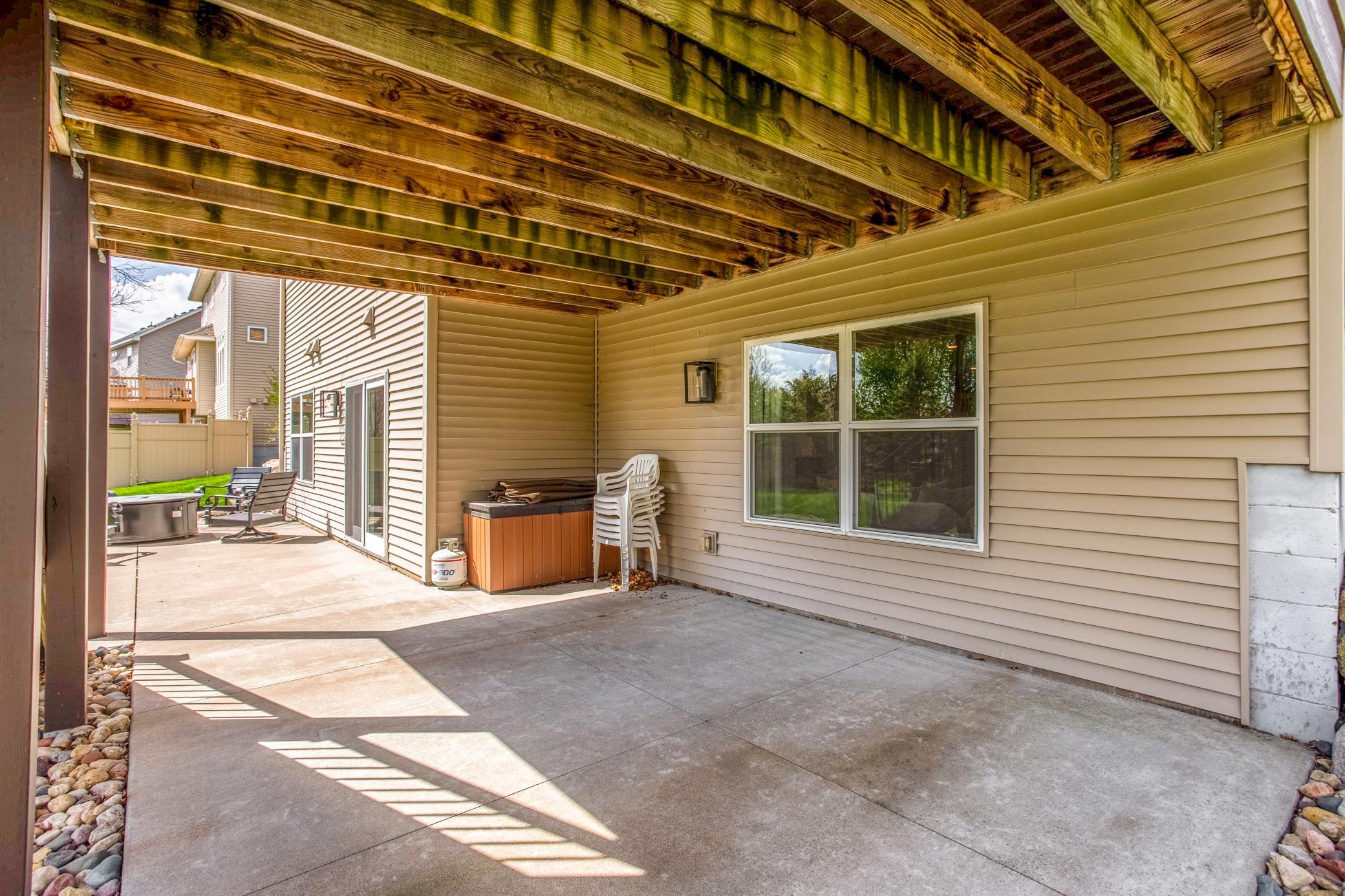 Spacious covered walkout patio with room for a hot tub area and ample space for relaxing or entertaining outdoors.