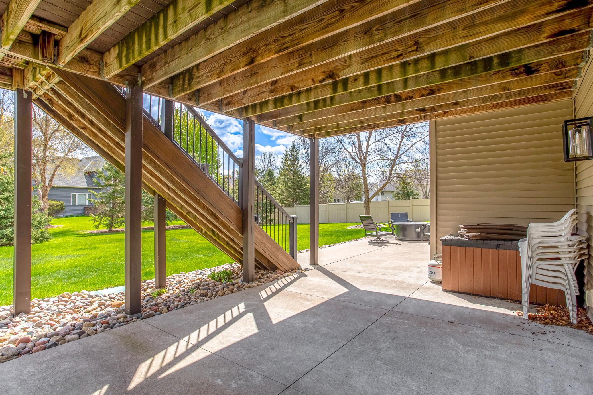 Covered patio space beneath the deck offers shade, versatility, and additional outdoor entertaining options.