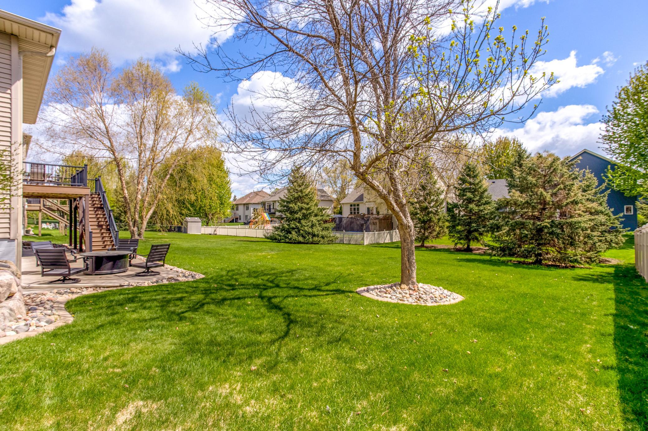 Beautifully landscaped backyard with mature trees, lush green space, and a private setting ideal for recreation and entertaining.
