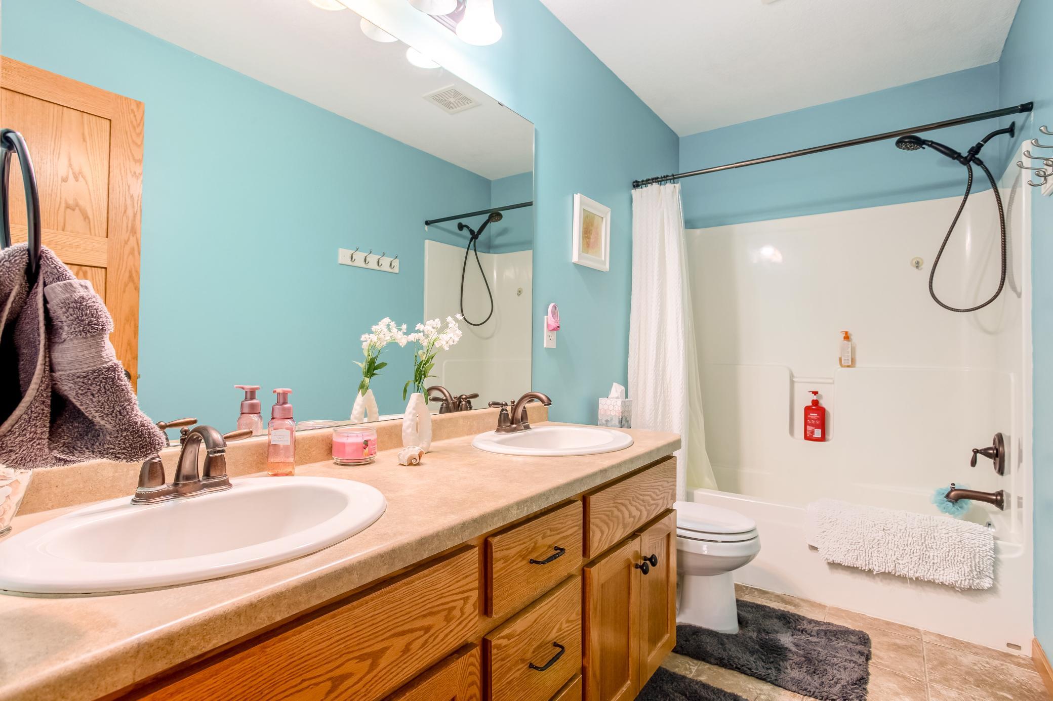 Spacious full bathroom with dual vanities, updated fixtures, and a convenient tub/shower combination.