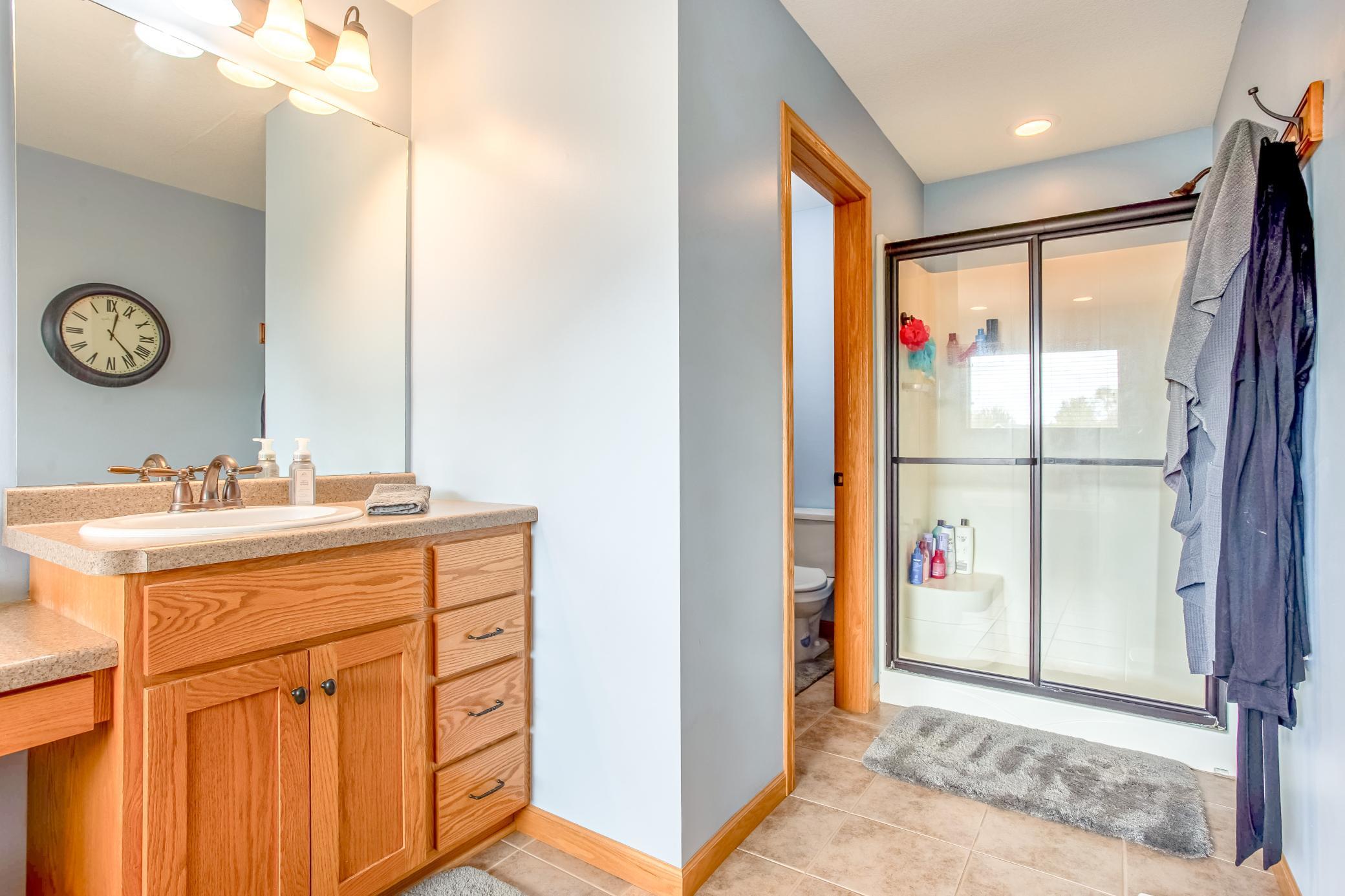 Spacious en suite bath featuring a walk-in shower, private water closet, and functional layout for everyday convenience.