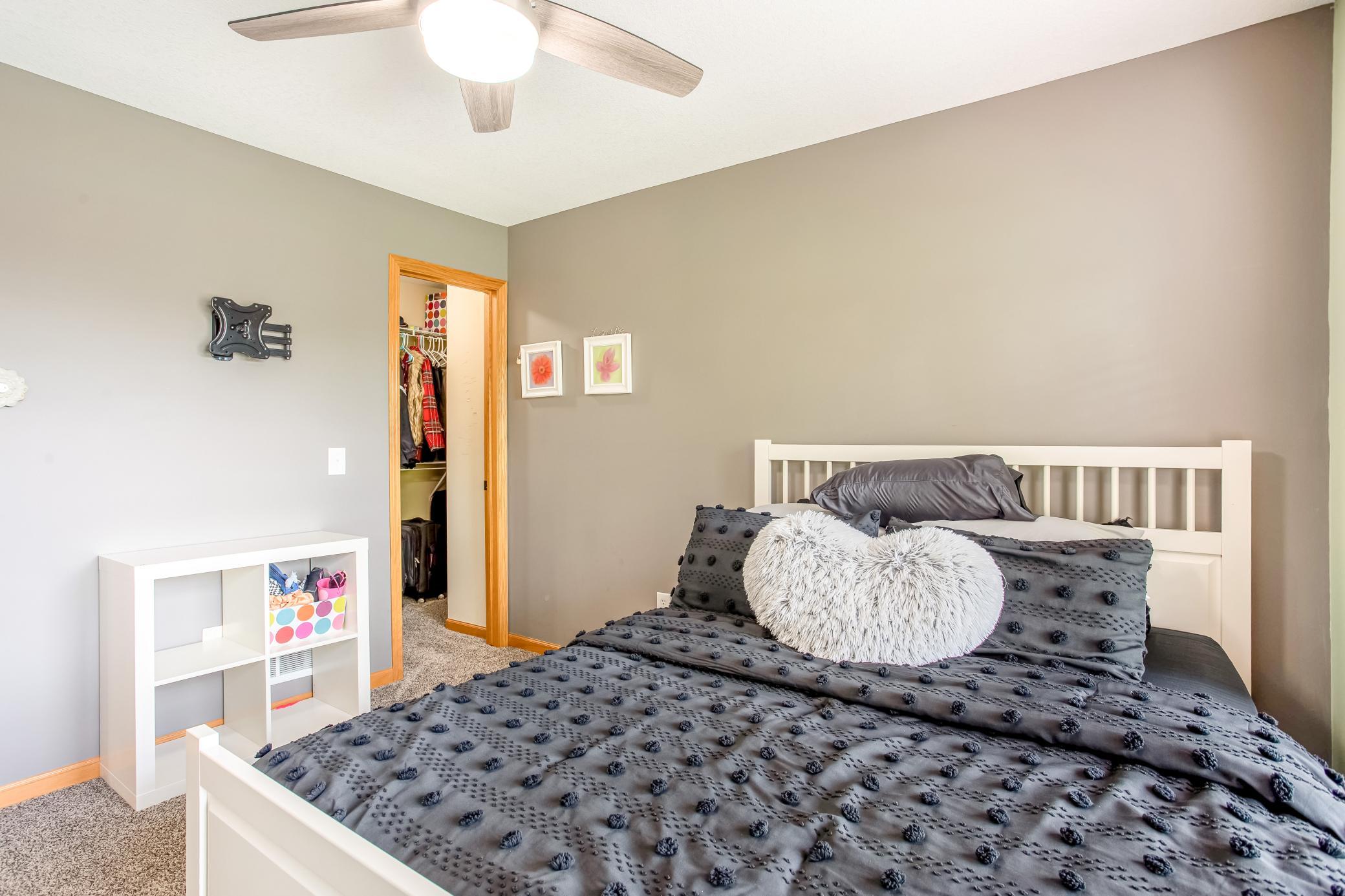 Cozy bedroom retreat with neutral tones, plush carpeting, and a spacious walk-in closet.