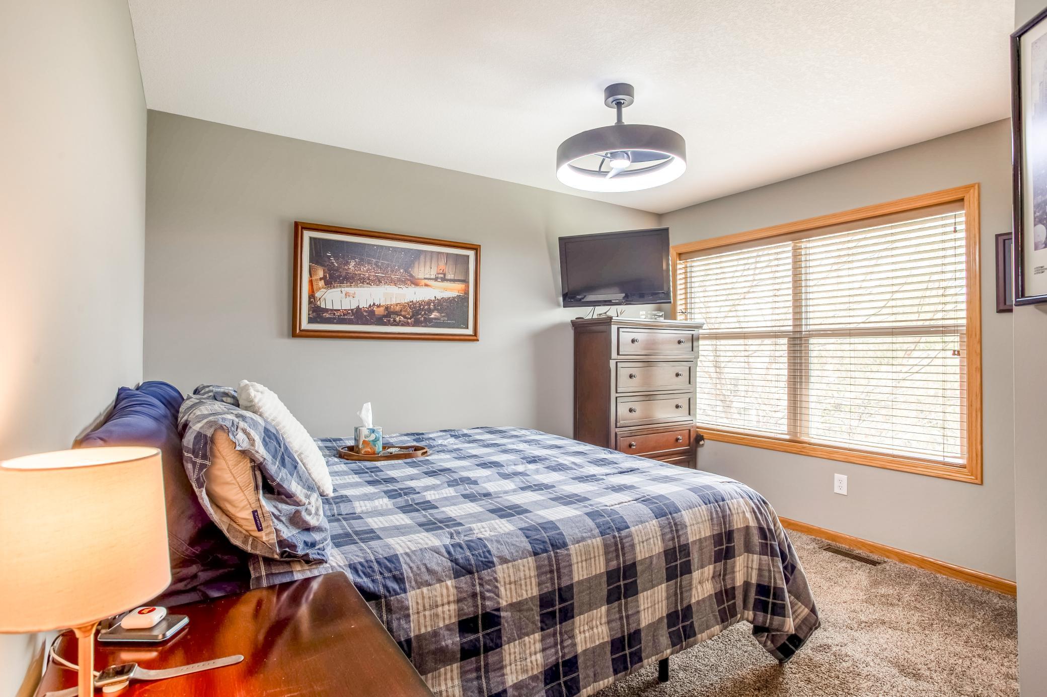 Comfortable secondary bedroom with large windows, soft natural light, and a warm, inviting feel.