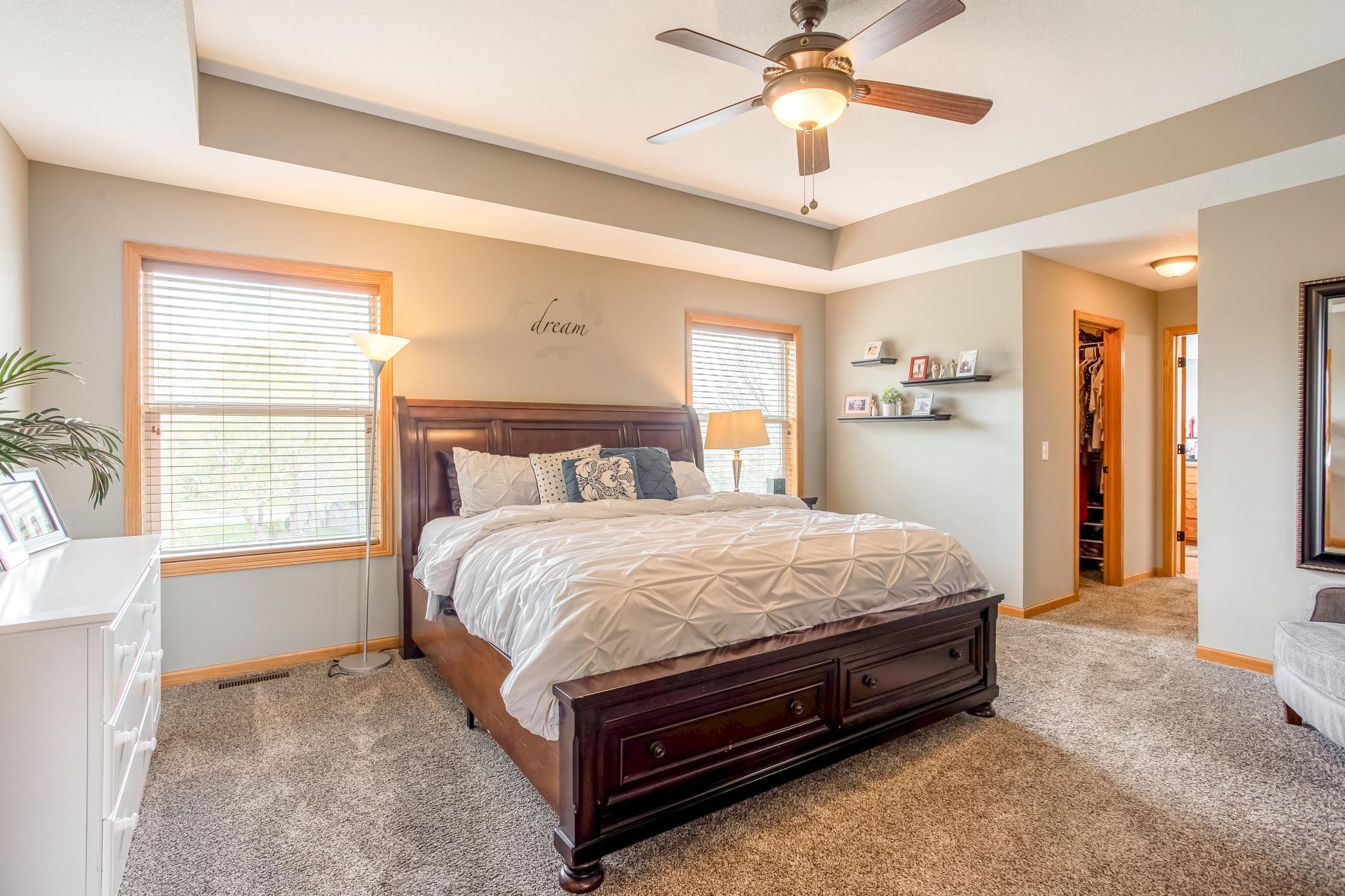 Expansive primary suite with tray ceilings, oversized windows, and a peaceful atmosphere designed for comfort and relaxation.
