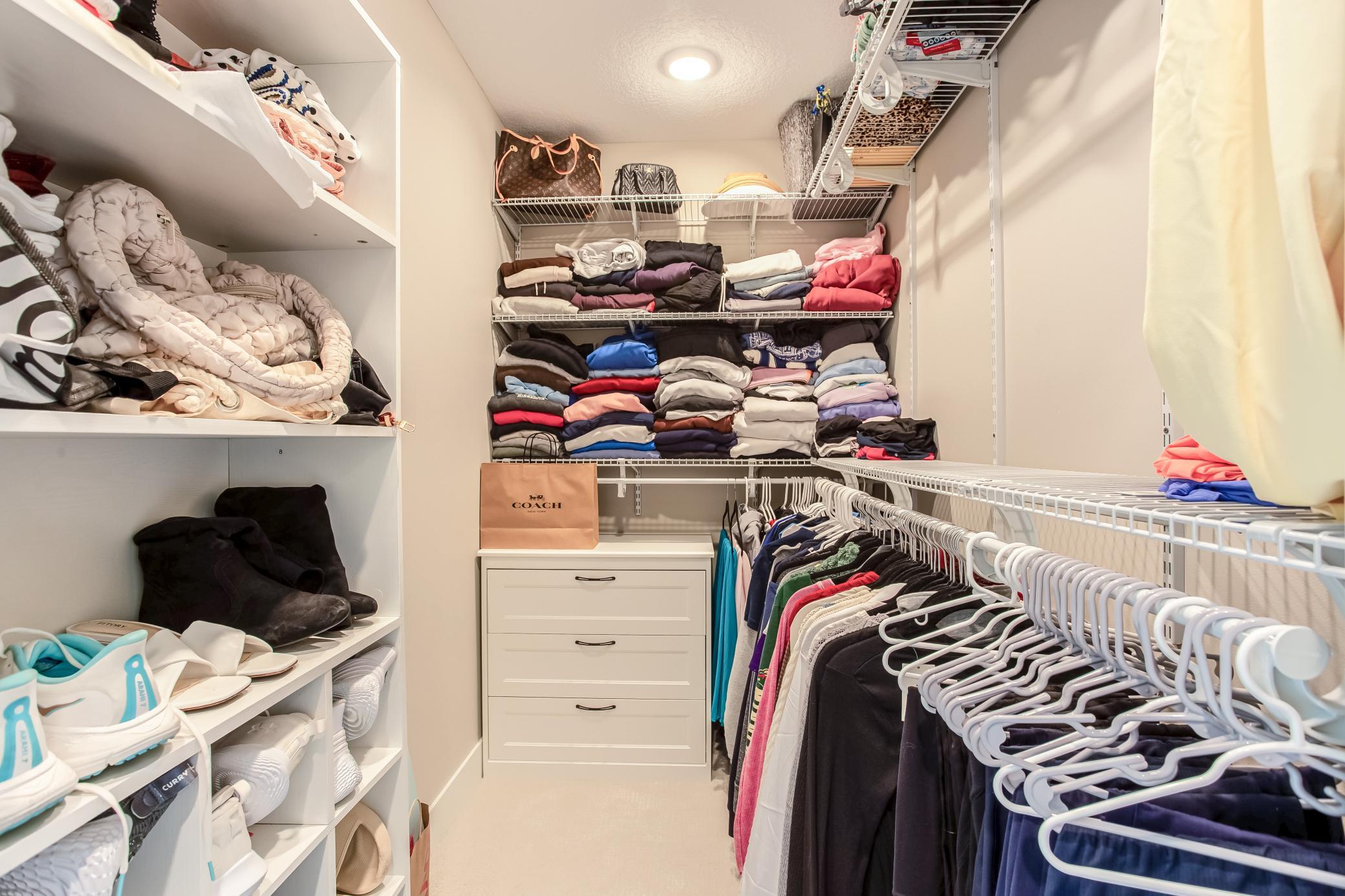 Spacious walk-in closet with custom shelving, abundant storage, and thoughtfully designed organization for everyday convenience.
