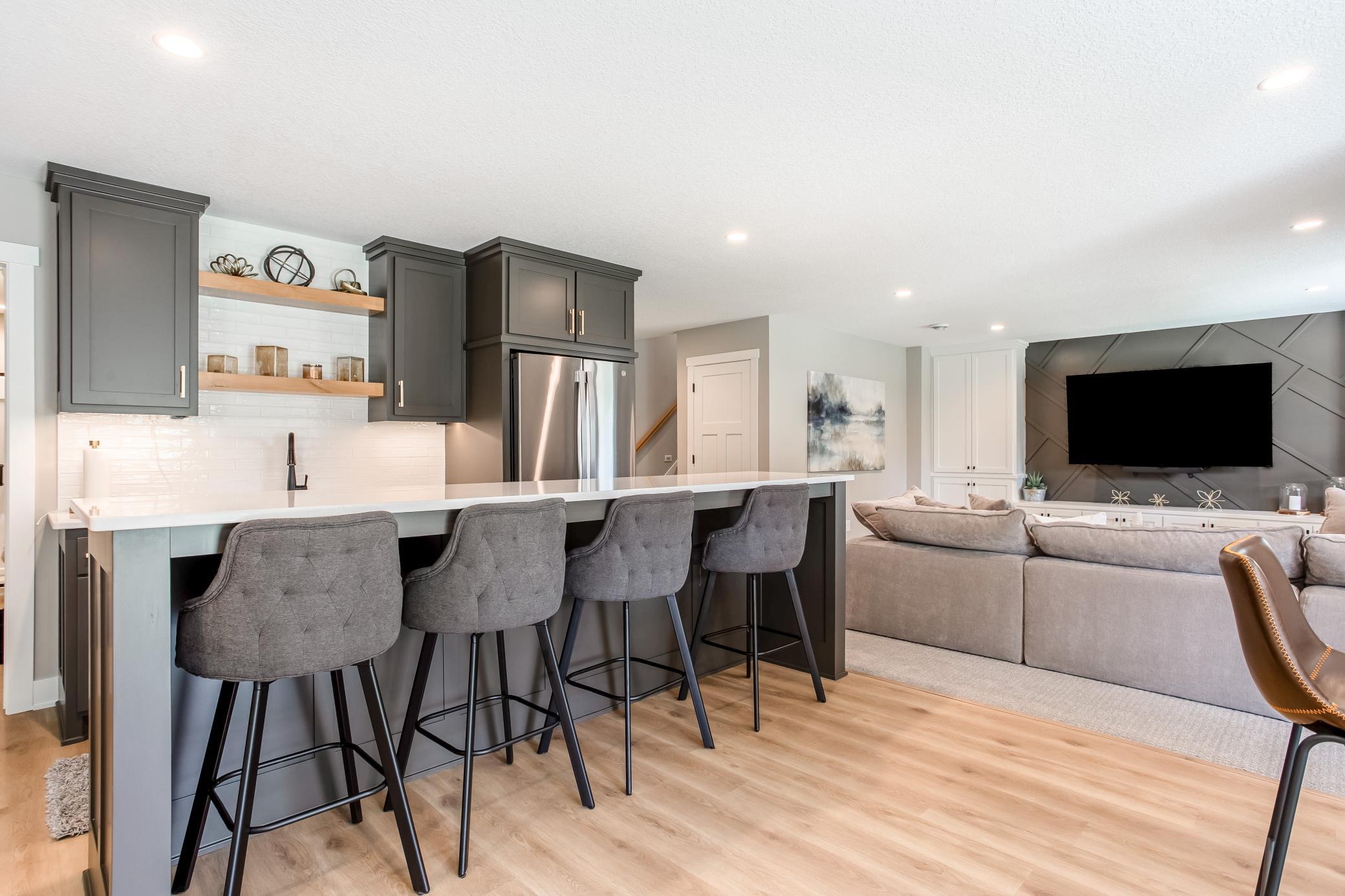 Modern entertaining space featuring a sleek wet bar, luxury finishes, and easy access to the adjacent family room.
