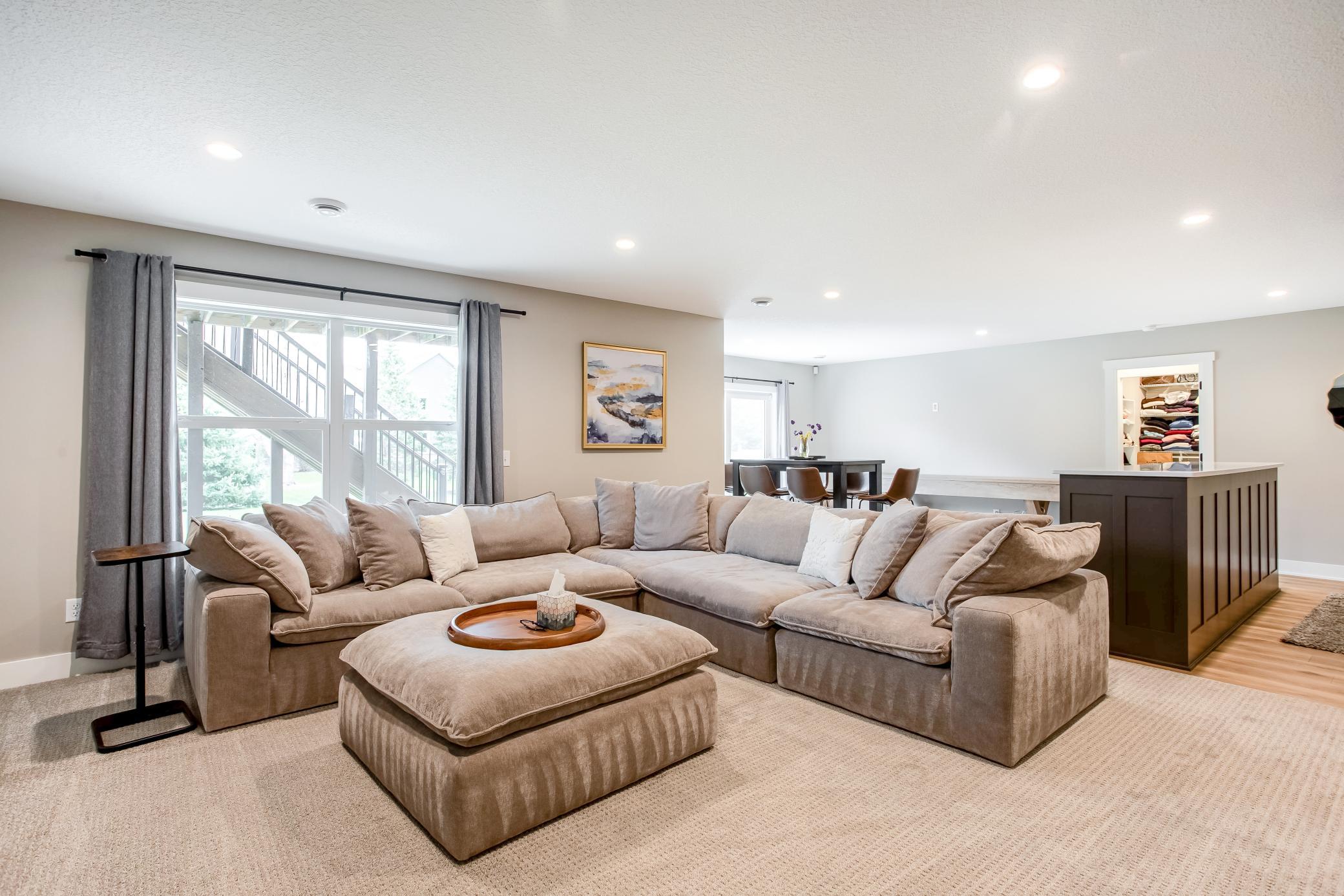 Open-concept lower level offering a spacious lounge area, natural light, and seamless flow for entertaining guests.