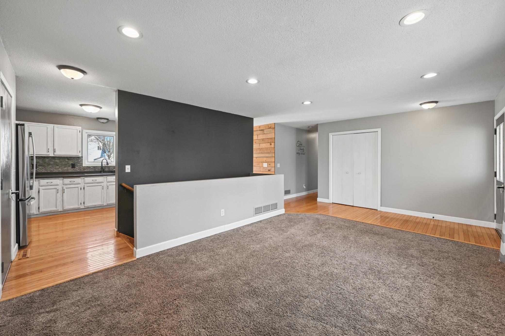 You can see the kitchen and down the hall, as well as the gorgeous hardwood floors