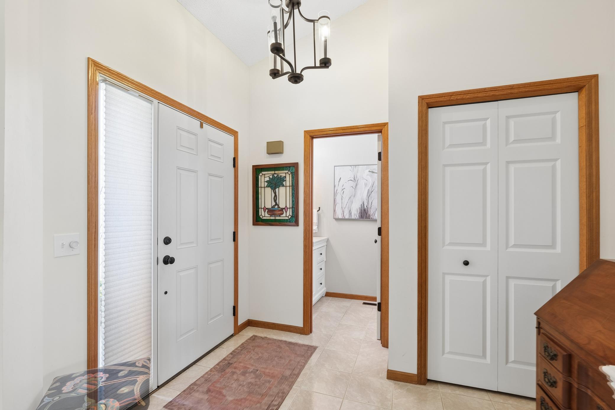 Spacious entry with new lighting and coat closet.