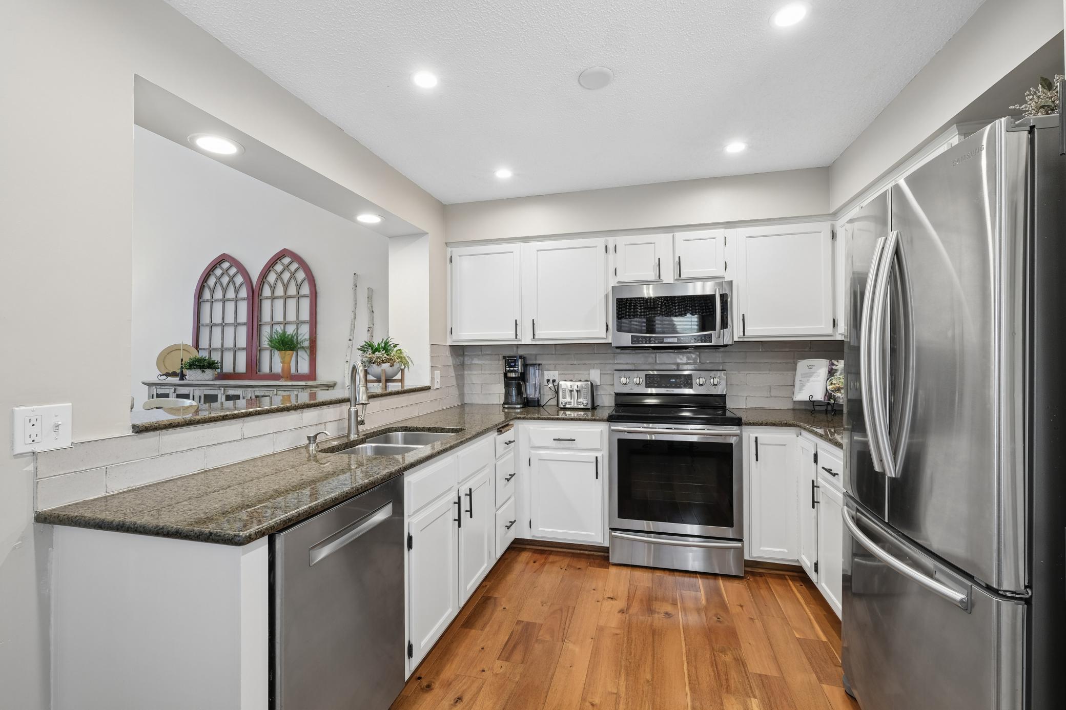 The kitchen cabinets were recently enameled. Tile backsplash, granite counters and newer appliances.