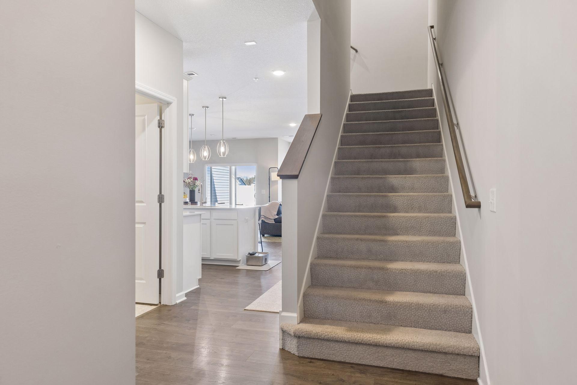 Entryway with staircase leading to upper level, offering a practical flow.