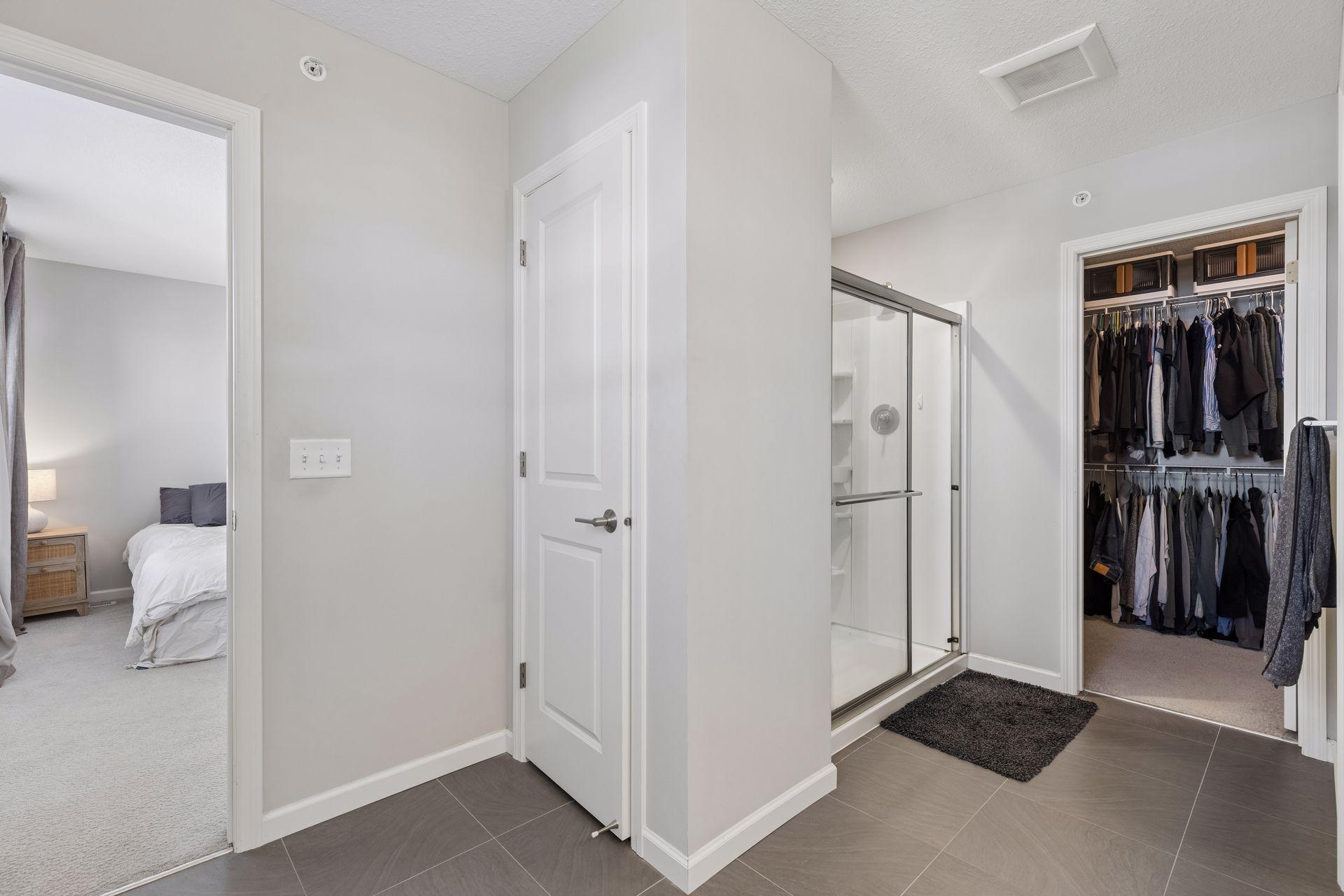Primary bathroom with walk-in shower, storage closet, and access to walk-in closet.