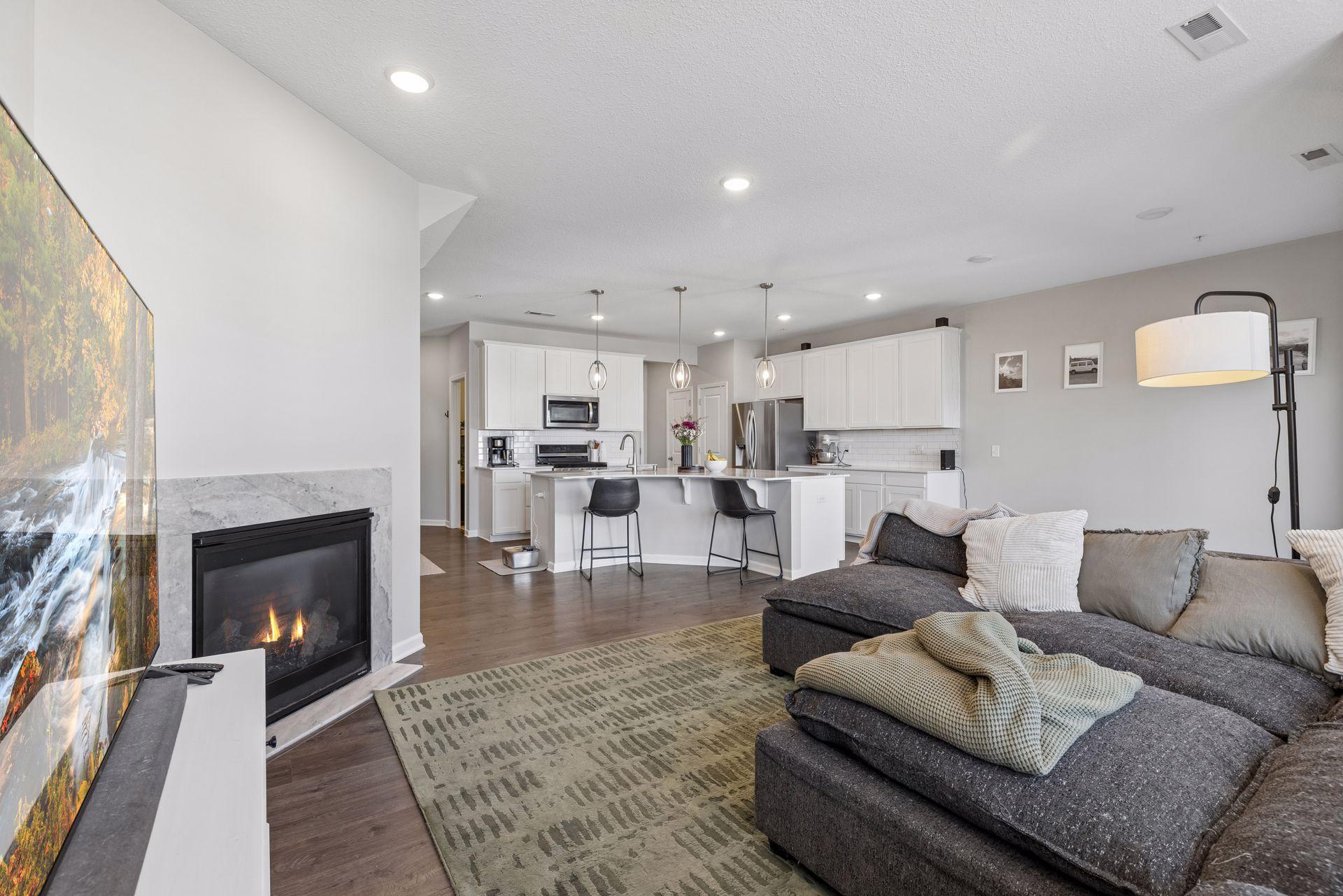 Living room with fireplace and open view toward kitchen, creating a comfortable gathering space.