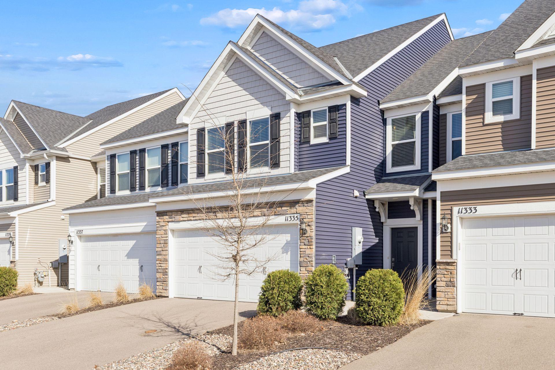 Front exterior view from the right showcasing attached garage, driveway space, and attractive exterior finishes.