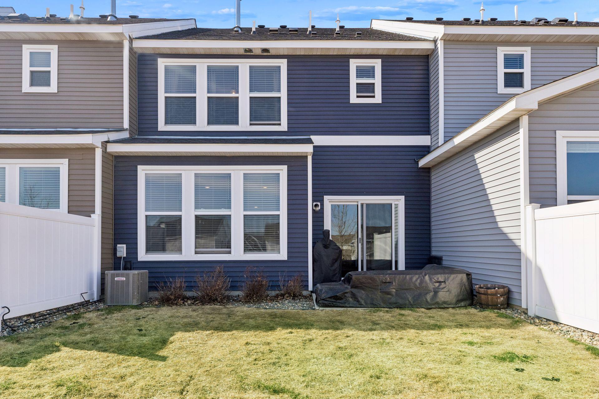 Back exterior showing sharp contract in the blue siding with white trim.