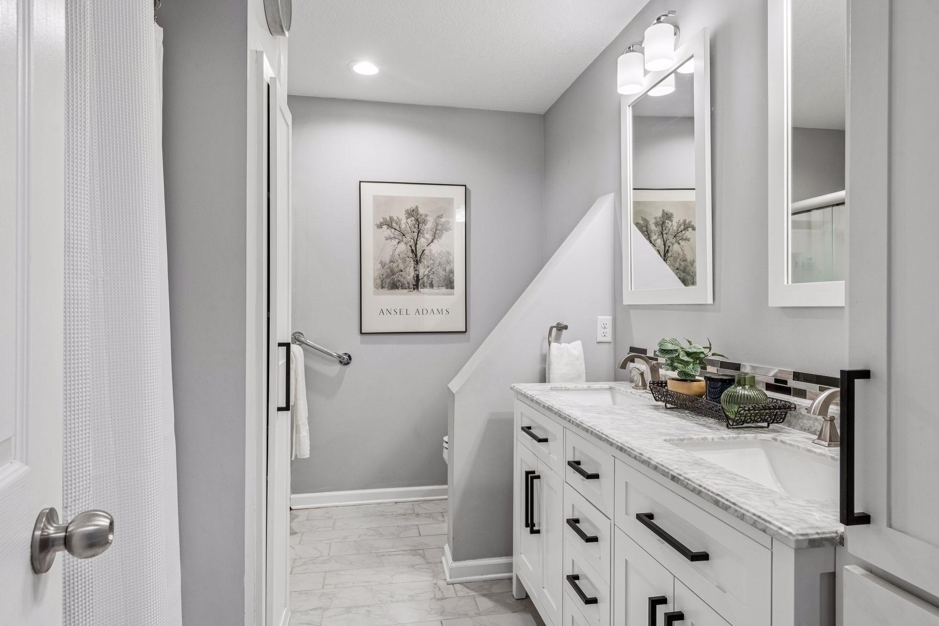 Upper level full bath with marble countertop, dual sinks, and separate tub/shower.