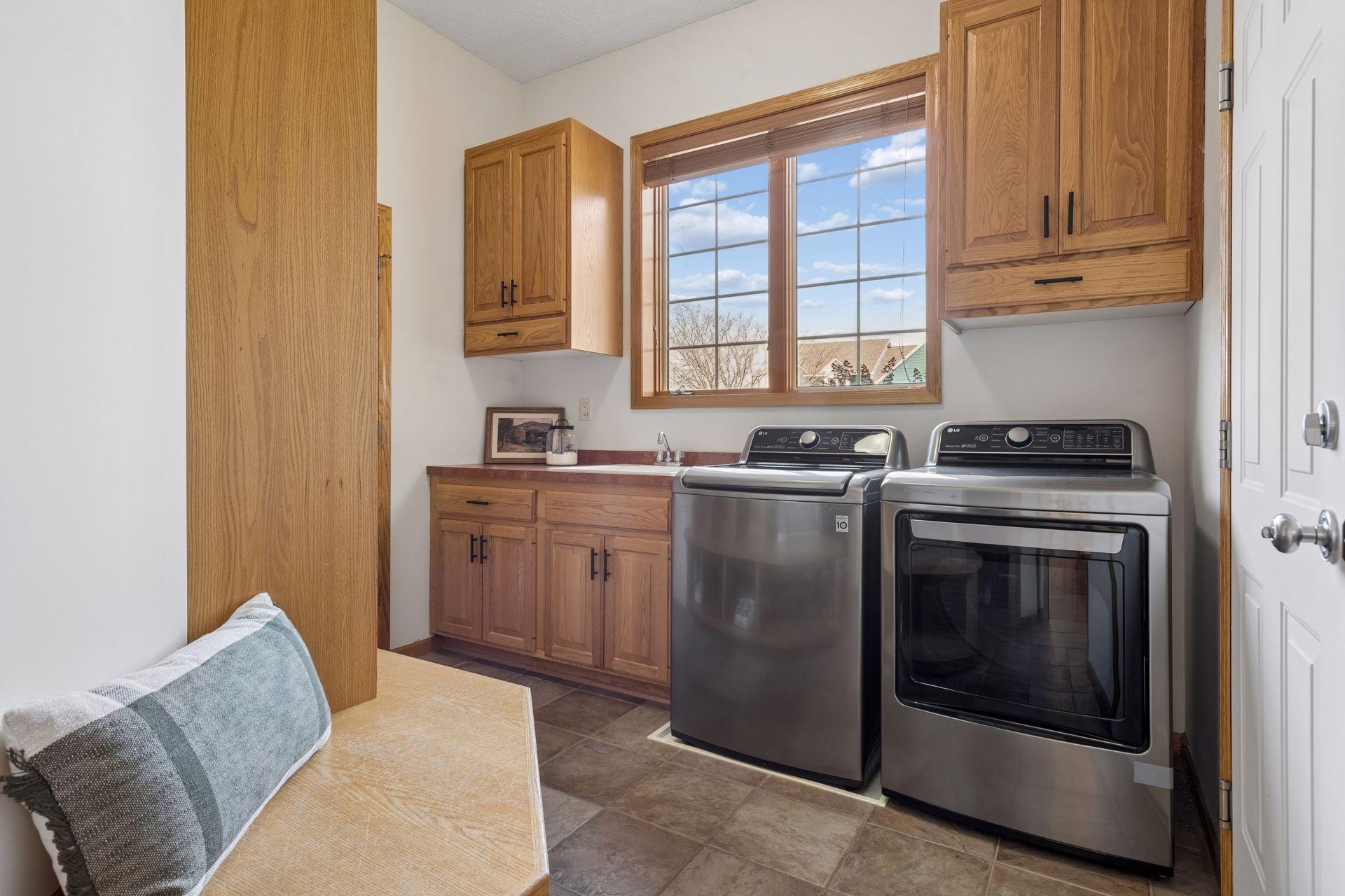 Main level laundry room w/ laundry sink, built-in lockers & large storage closet