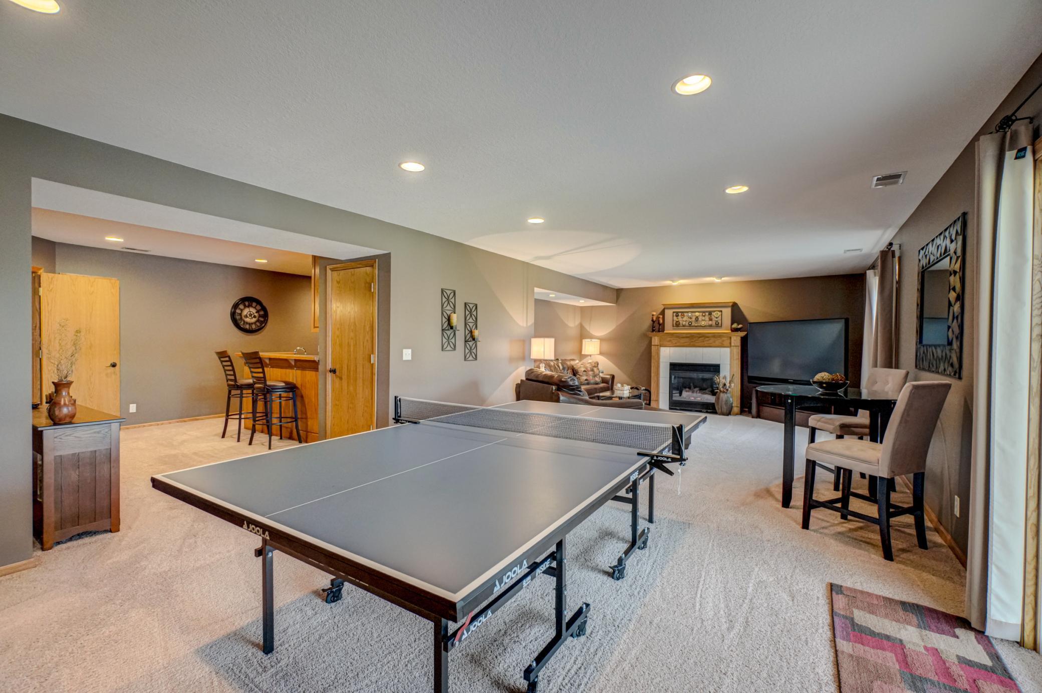 Cozy lower-level family room with a gas fireplace and seamless walkout access to the pool and hot tub