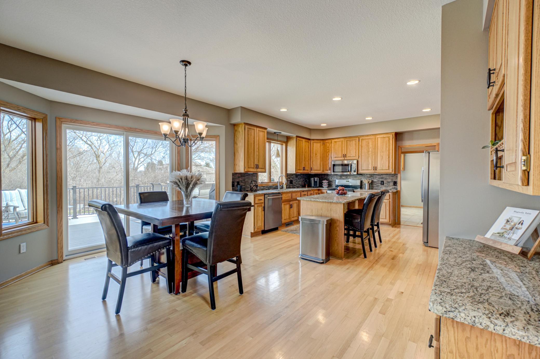 Warm hardwood floors flow through the kitchen and dining area