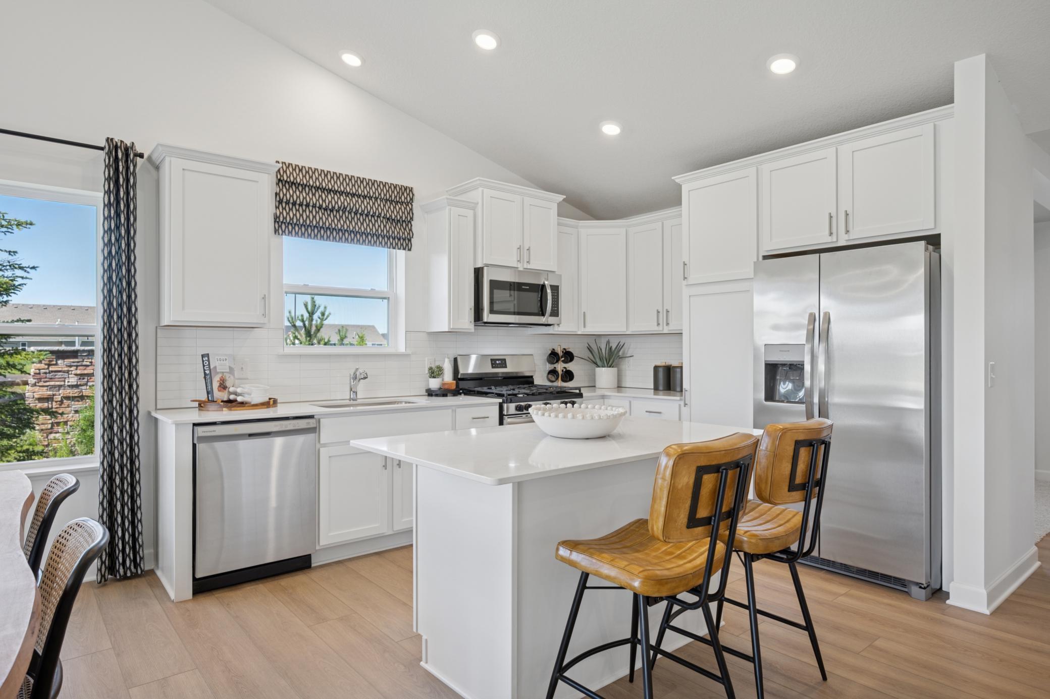 (Photo of a model home, finishes will vary) The chef-inspired kitchen showcases and elevated design, overlooking the dining room and Great Room and equipped with new appliances and a large center island that adds bar-style seating.