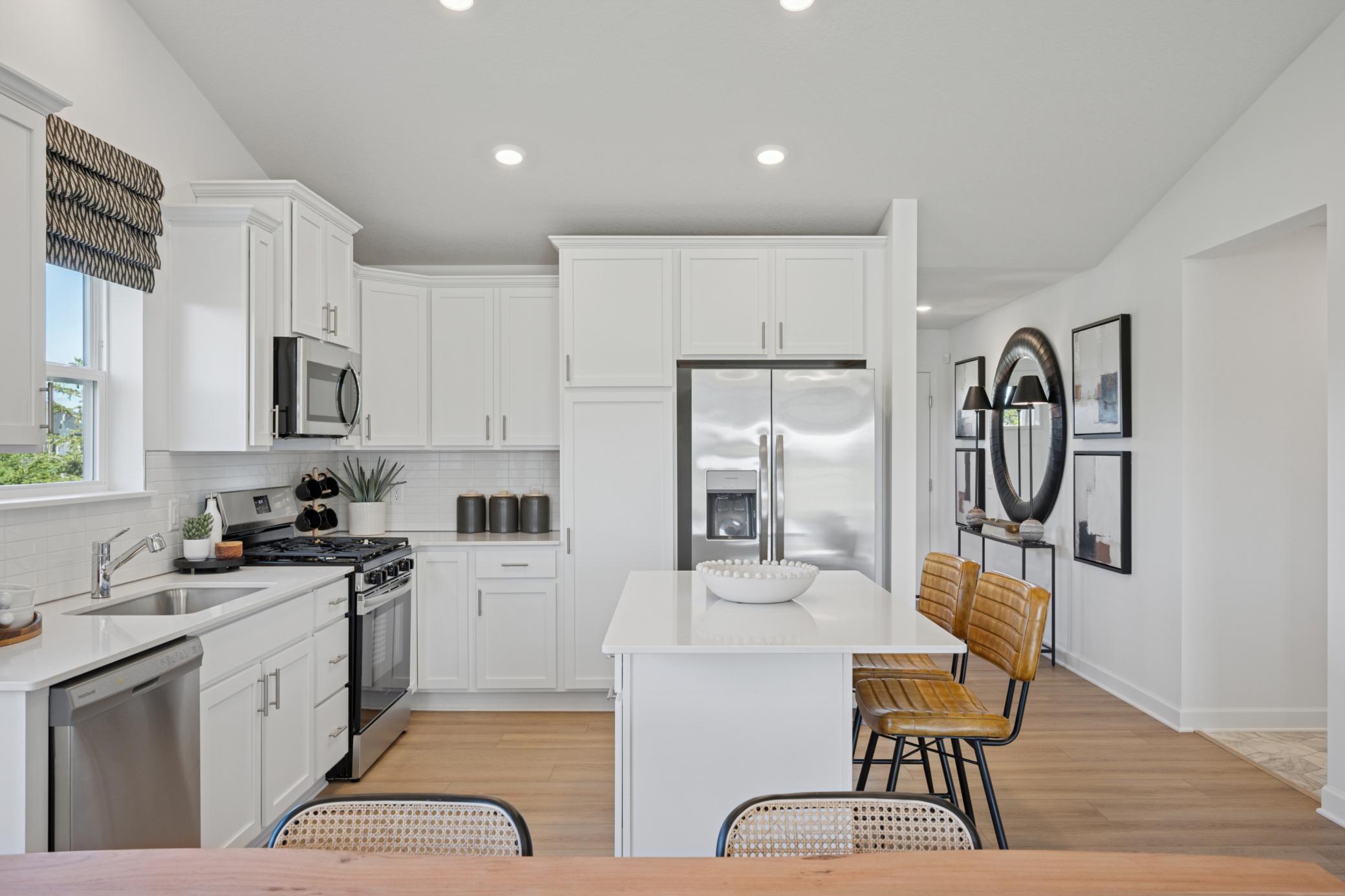 (Photo of a model home, finishes will vary) Designer-selected cabinetry throughout the kitchen offers ample storage room for dishware and daily culinary essentials