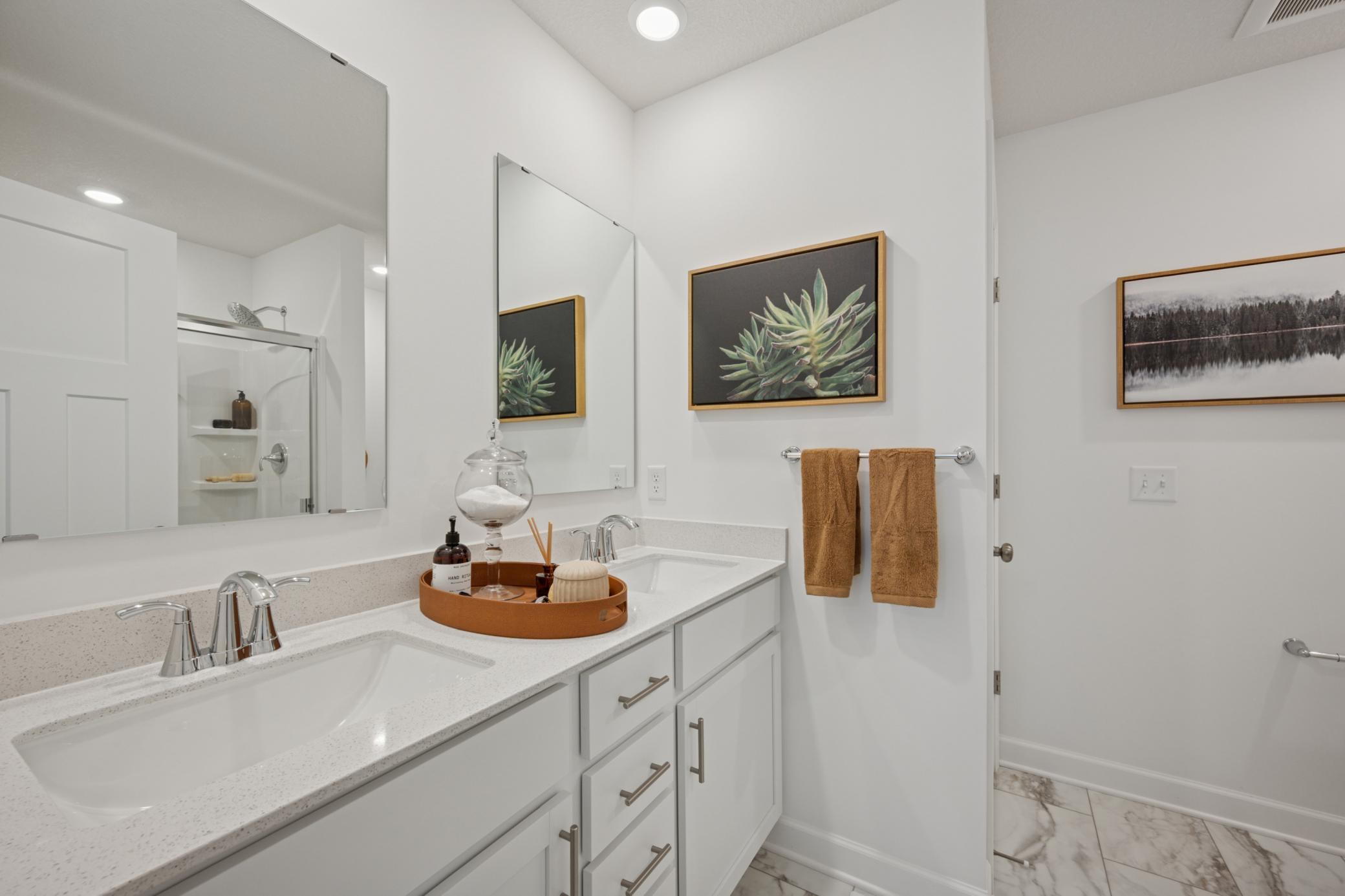 (Photo of a model home, finishes will vary) A quartz-topped vanity with dual sinks and plenty of cabinet space optimizes shared living