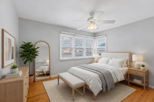 One of three main-level bedrooms featuring hardwood floors and plenty of natural light. **Virtually staged to show design options.**