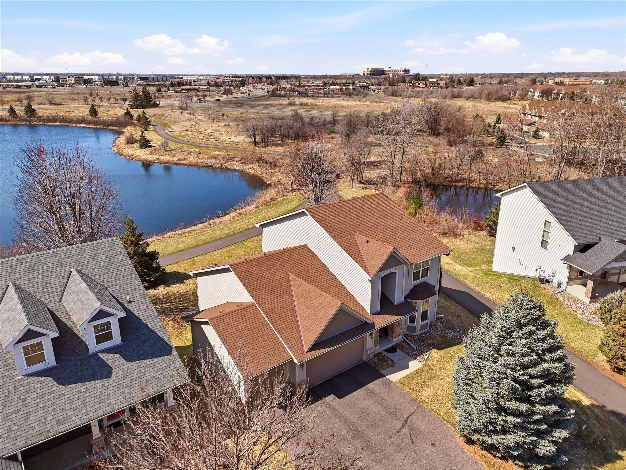 Front aerial view of home, trail and pond