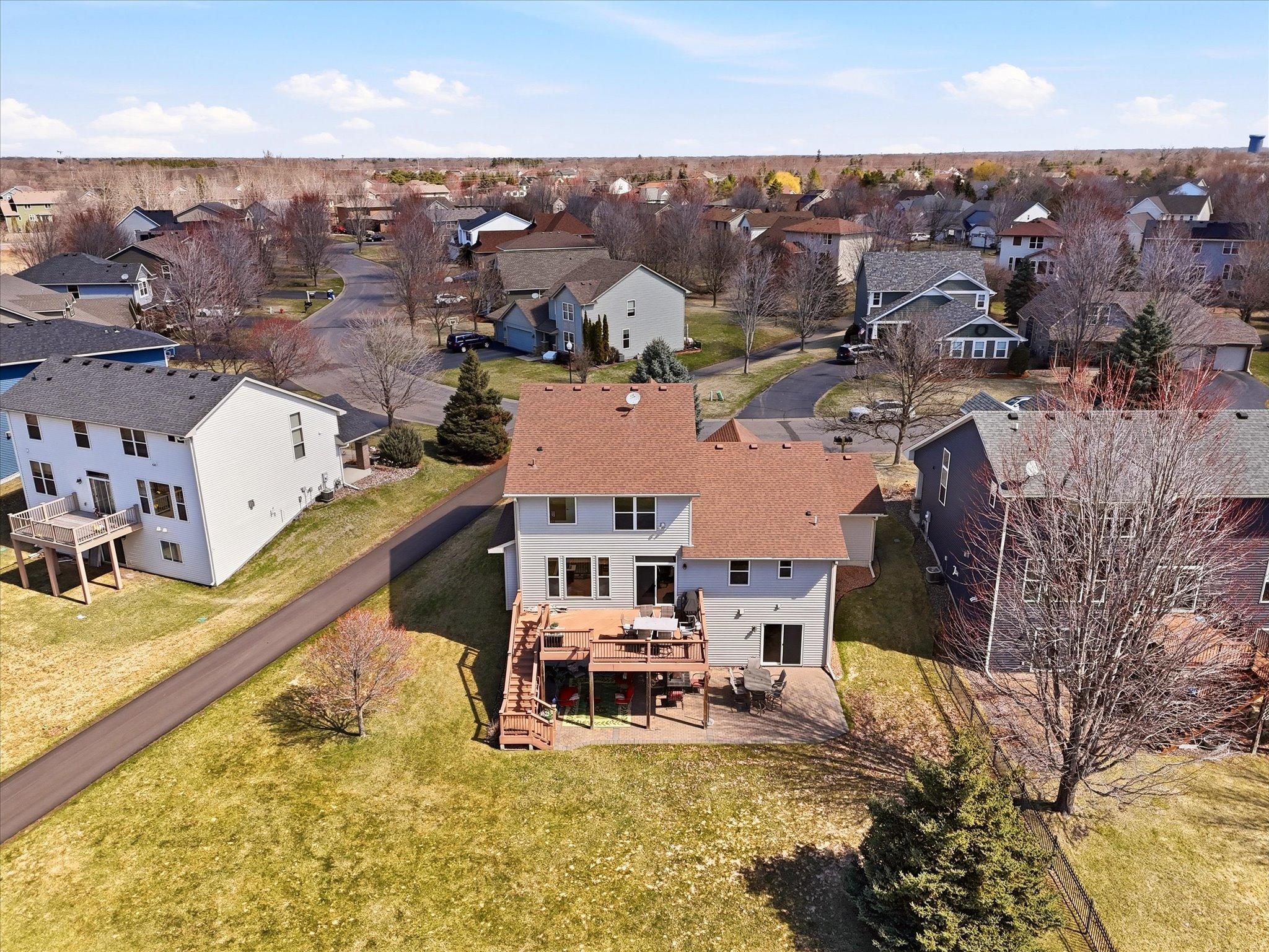 Spacious private backyard with deck and walkout lower level to paver patio